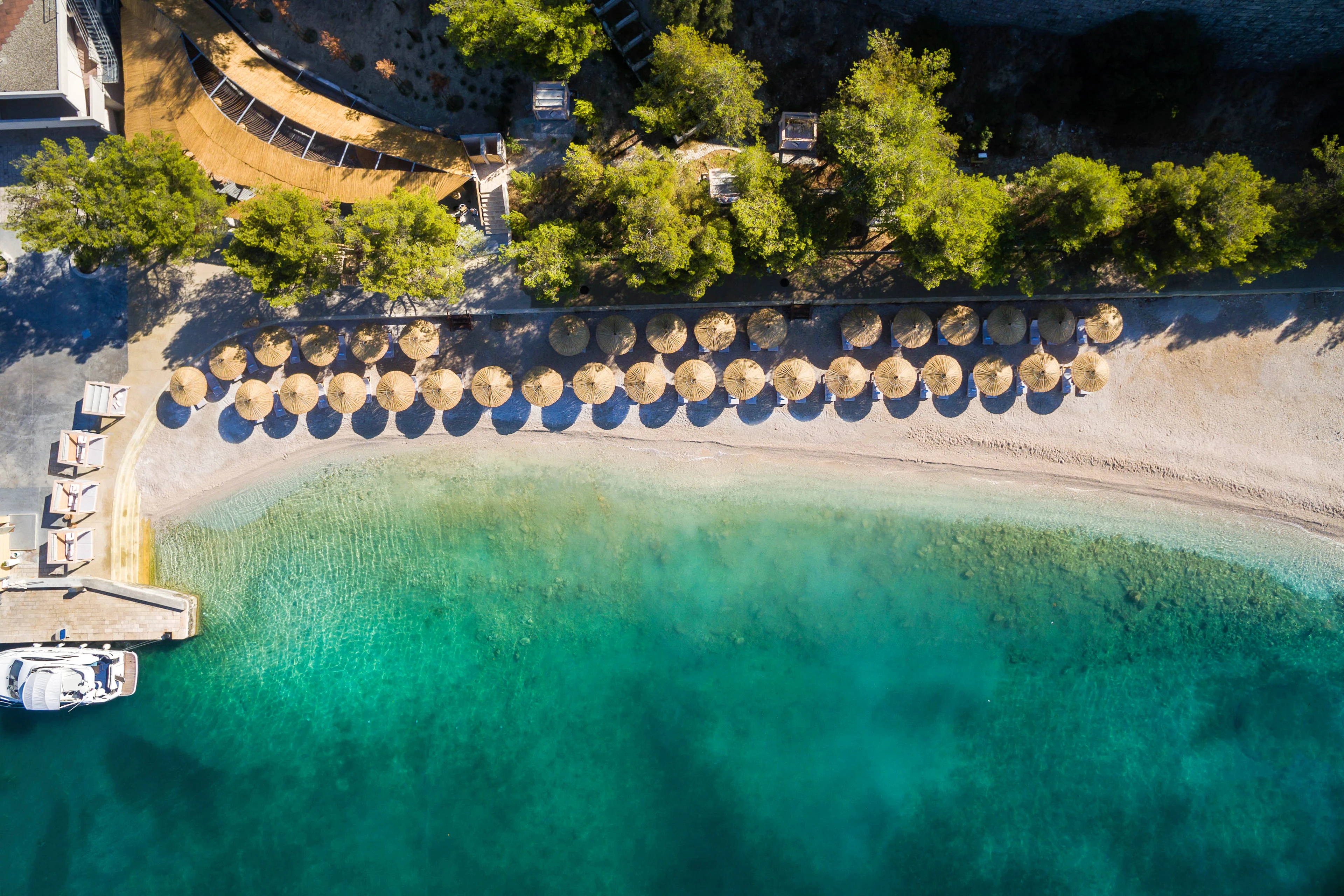 Flygfoto över stranden och det kristallklara vattnet på Ghooshter beach club i Podstrana.