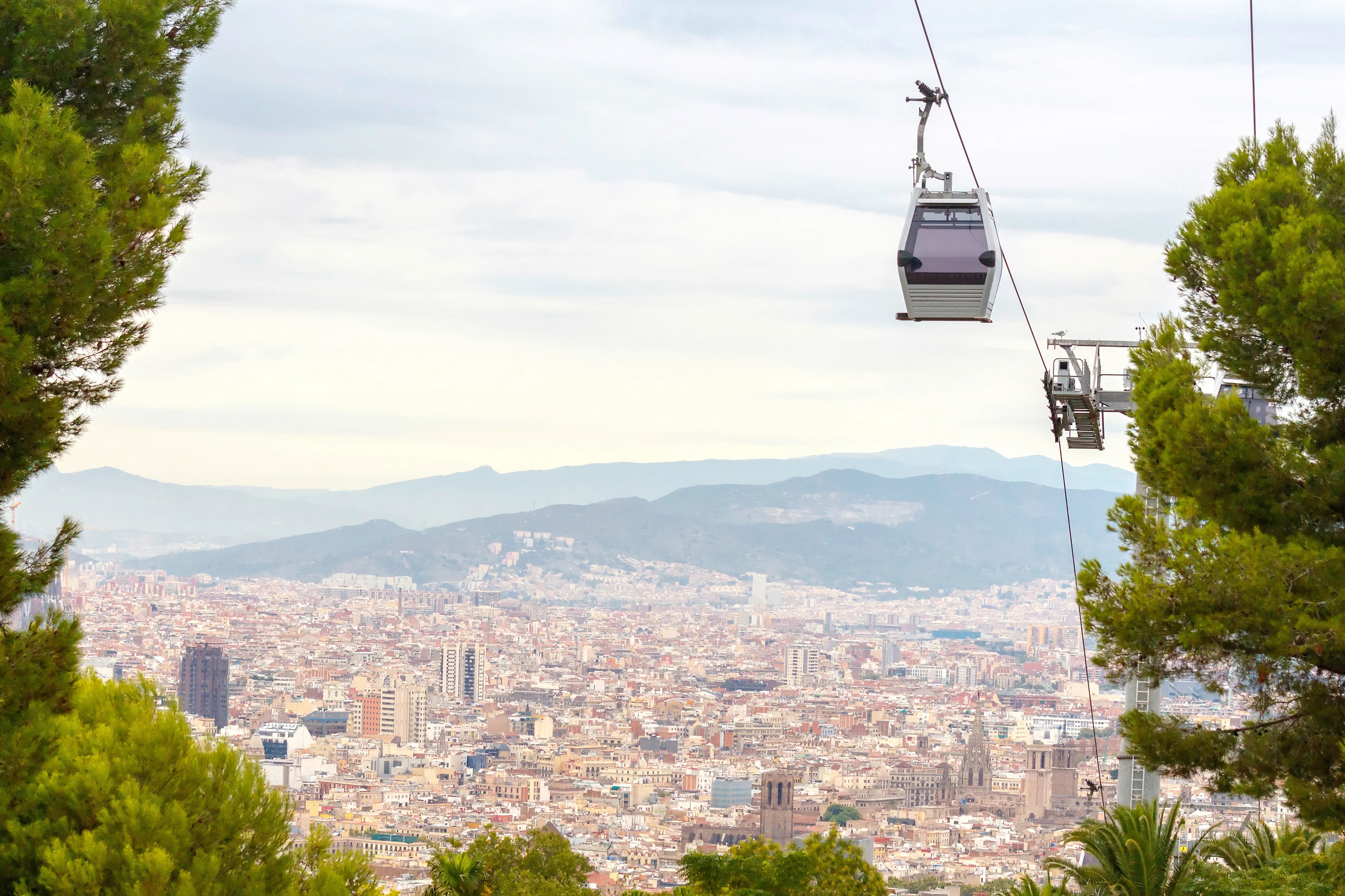 Linbana över Barcelona med panoramautsikt över staden och bergen i bakgrunden.