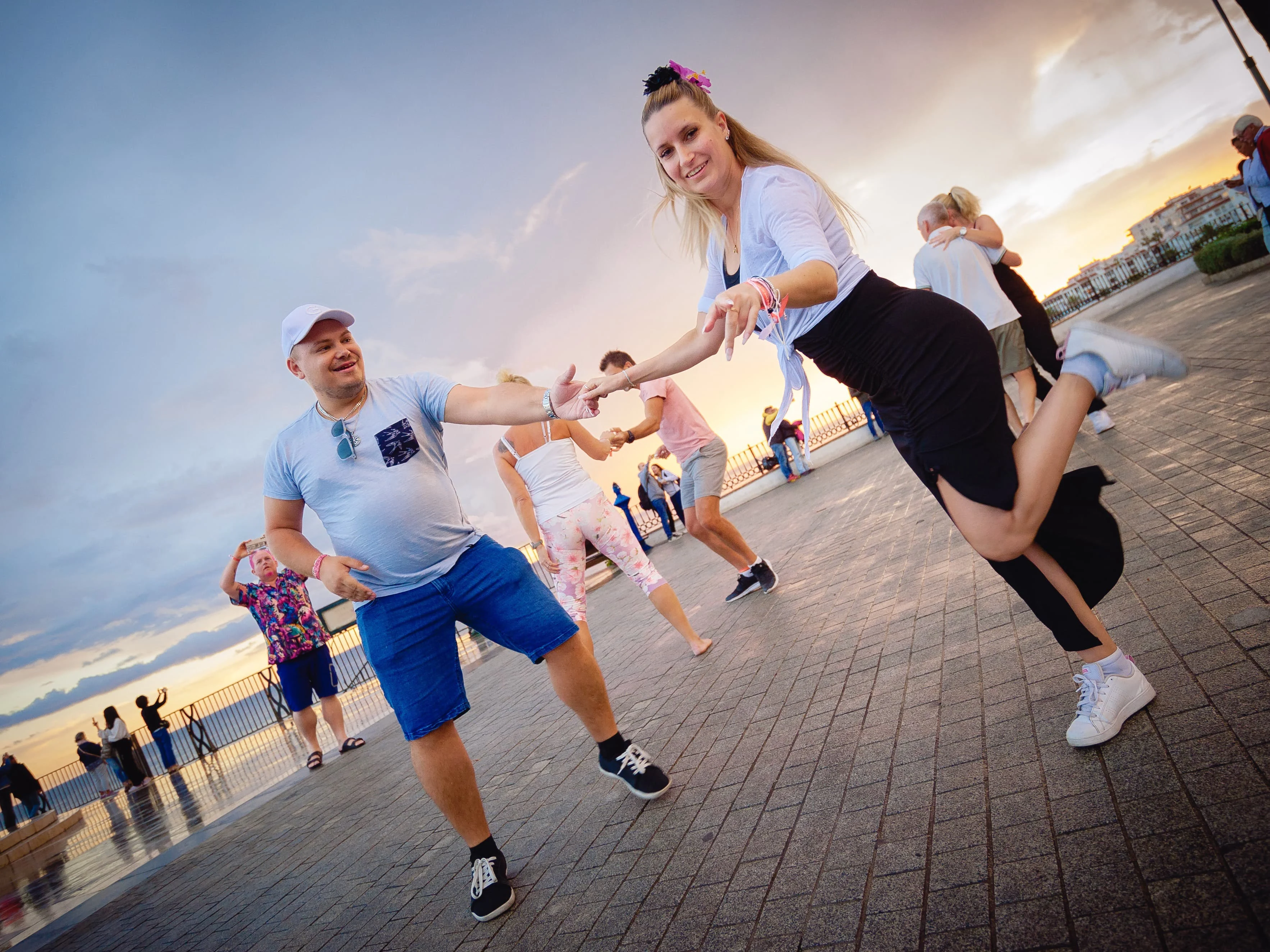 Happy Dance-instruktörer dansar med solnedgången i bakgrunden