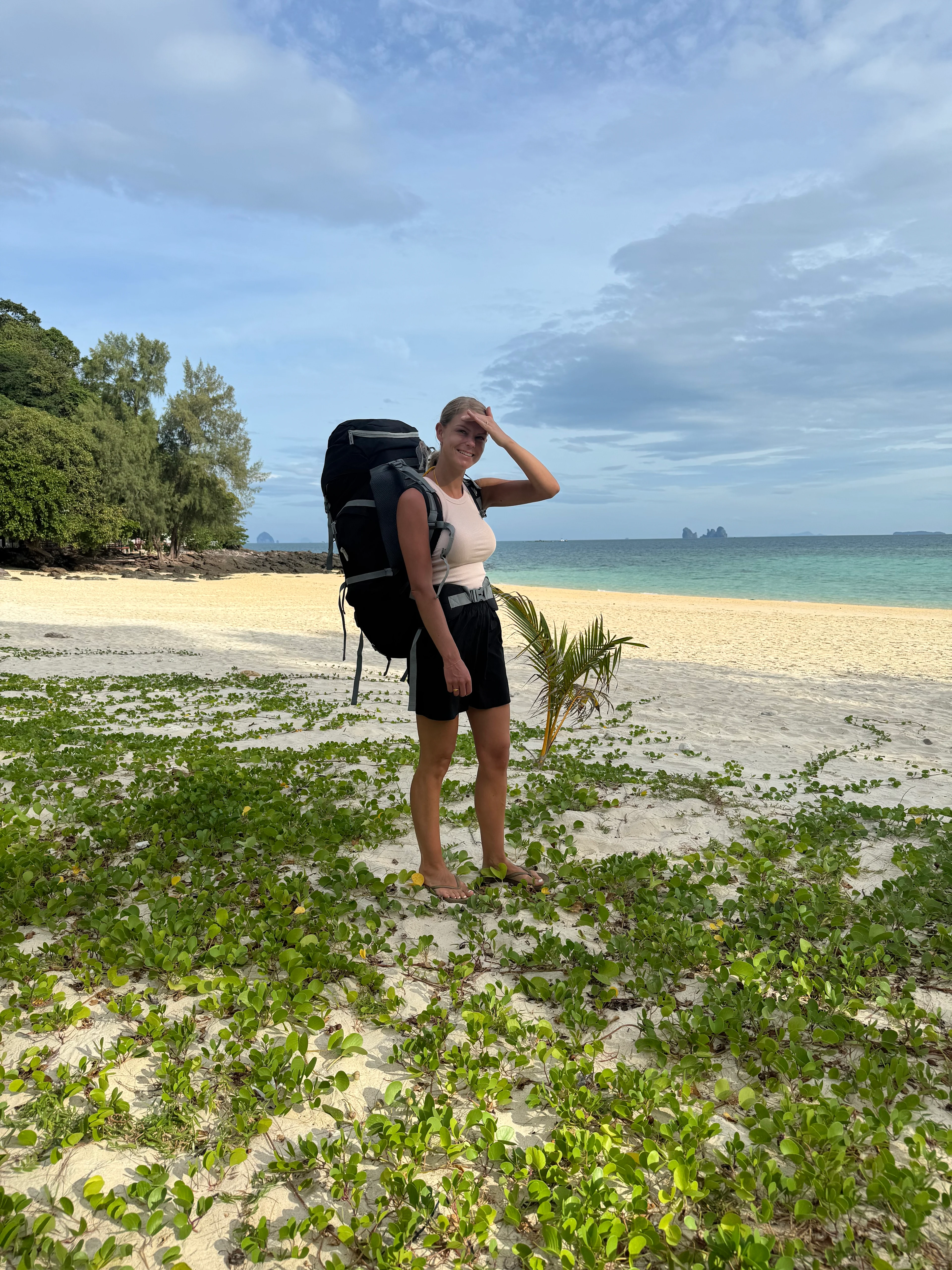 Line Rømer Borregaard med en stor ryggsäck på en strand.