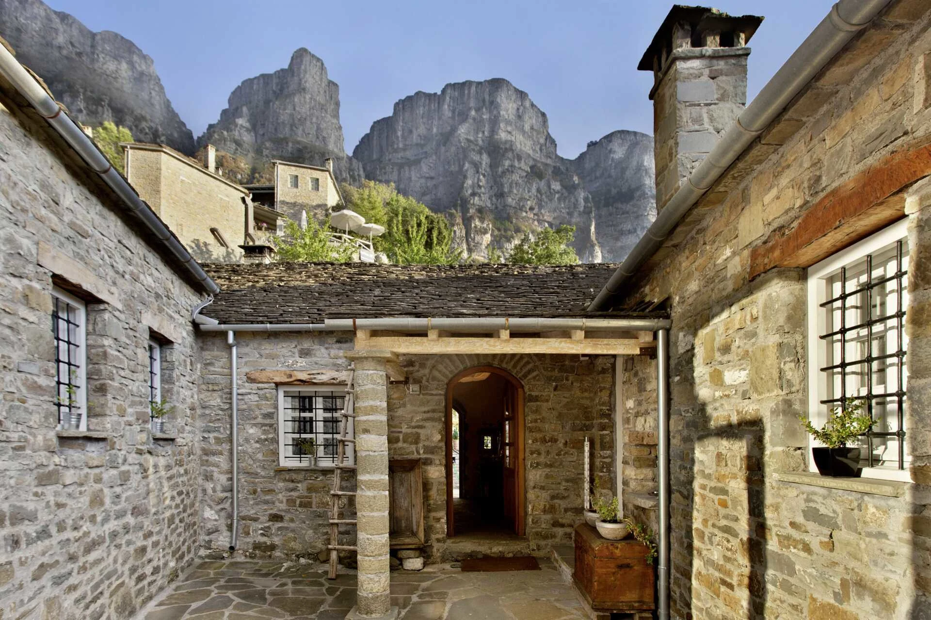 Inngangspartiet til Mikro Papigo 1700 Hotel & Spa med de høye fjellene i bakgrunnen.