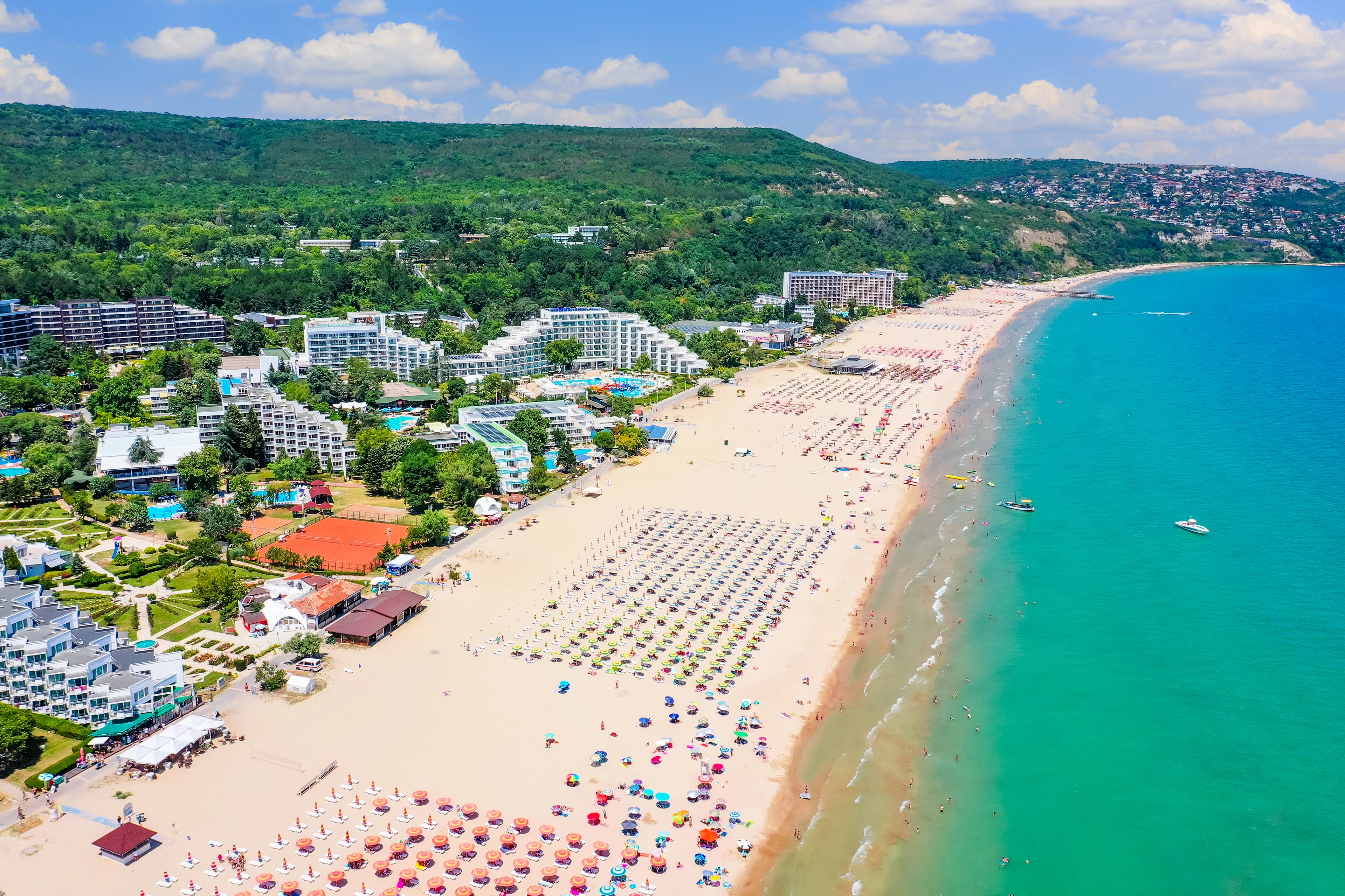 Flyfoto av Albena i Bulgaria med lang sandstrand, turkisblått hav og hotell langs kysten