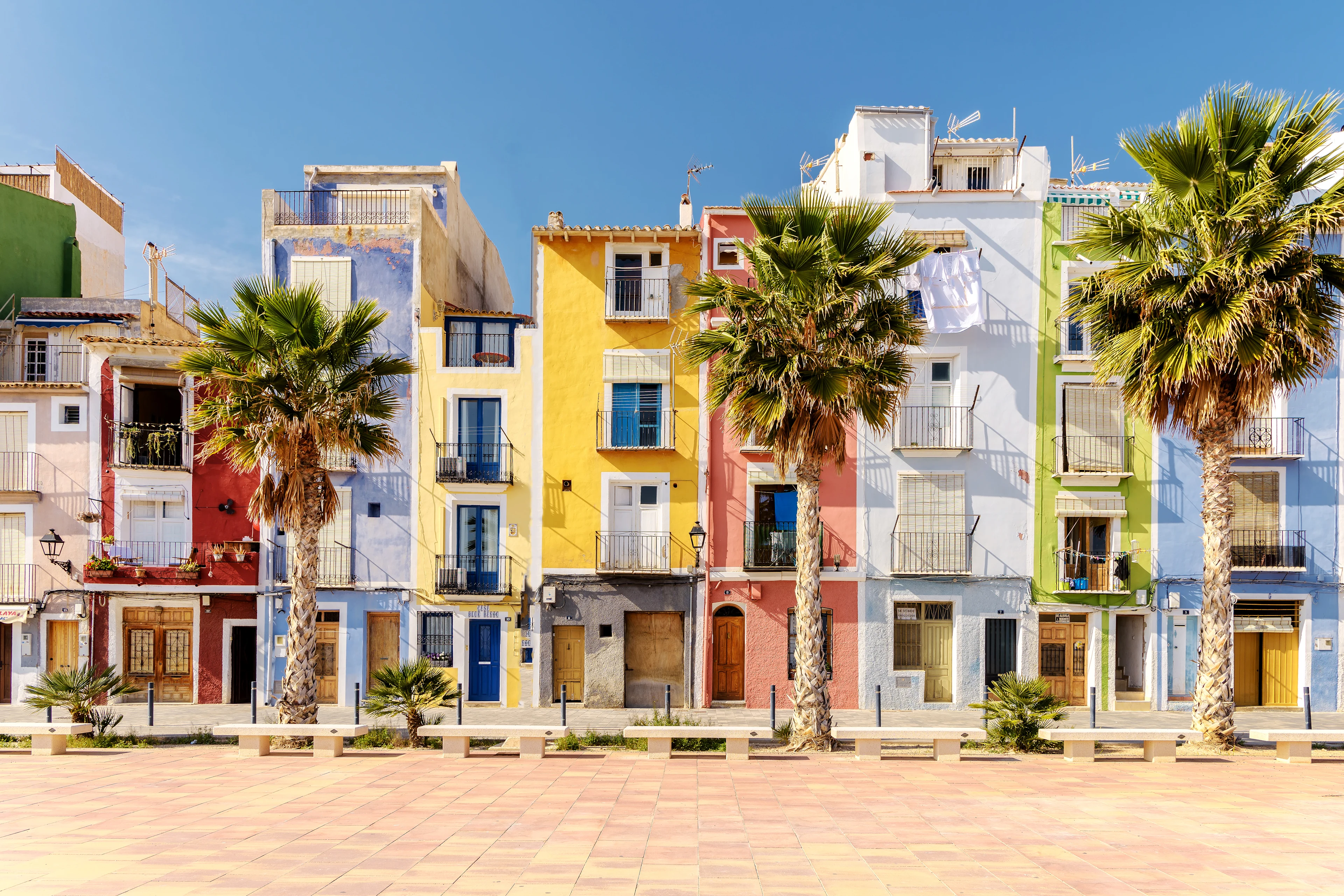 Colorful houses on beach promenade.