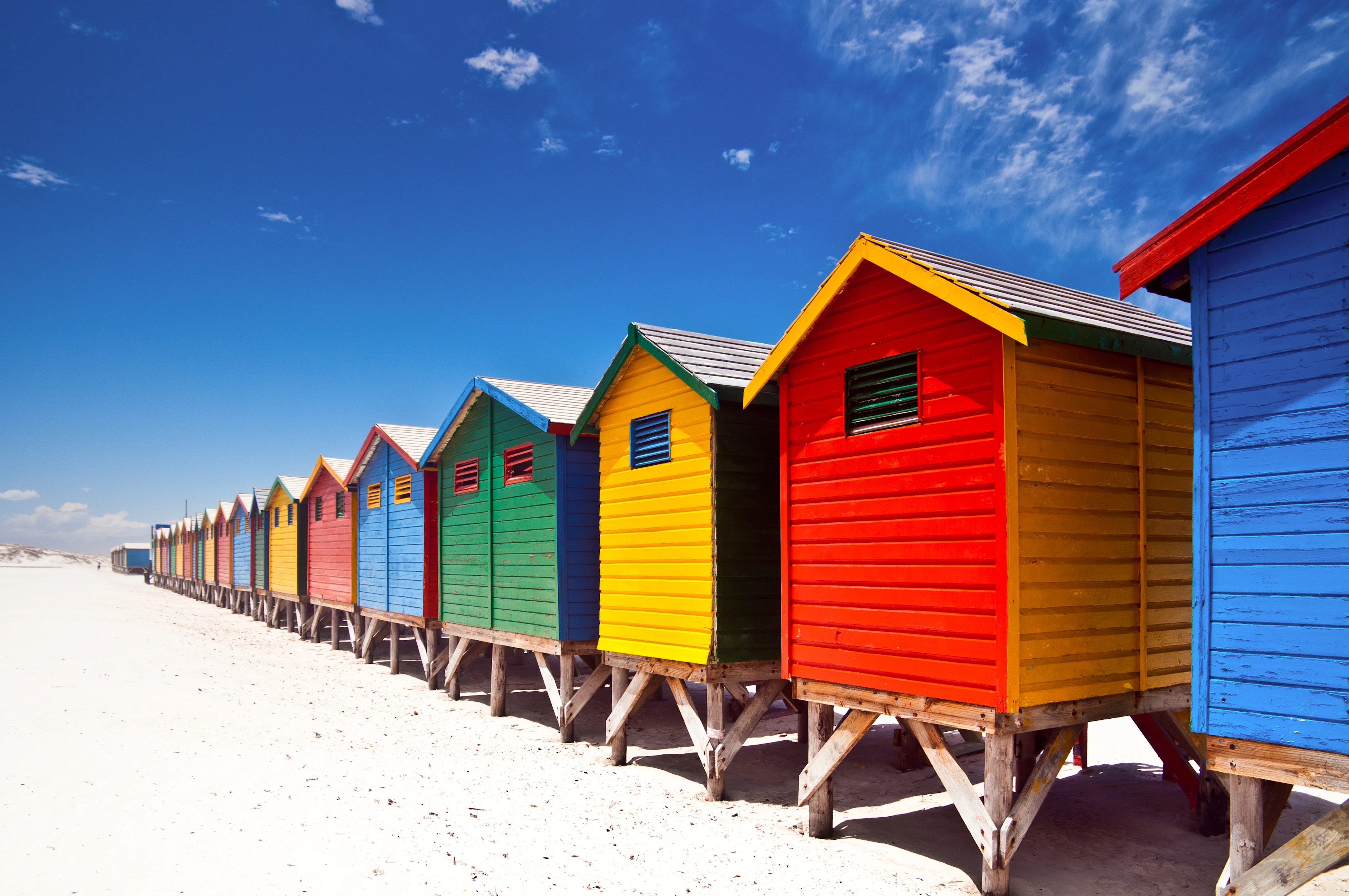 Färgglada badhytter längs stranden i Muizenberg nära Kapstaden.