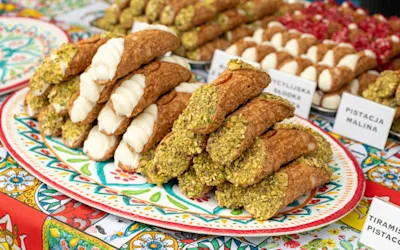 Tradisjonell siciliansk cannoli med ricotta, pistasjnøtter og diverse fyll på et lokalt matmarked på Sicilia
