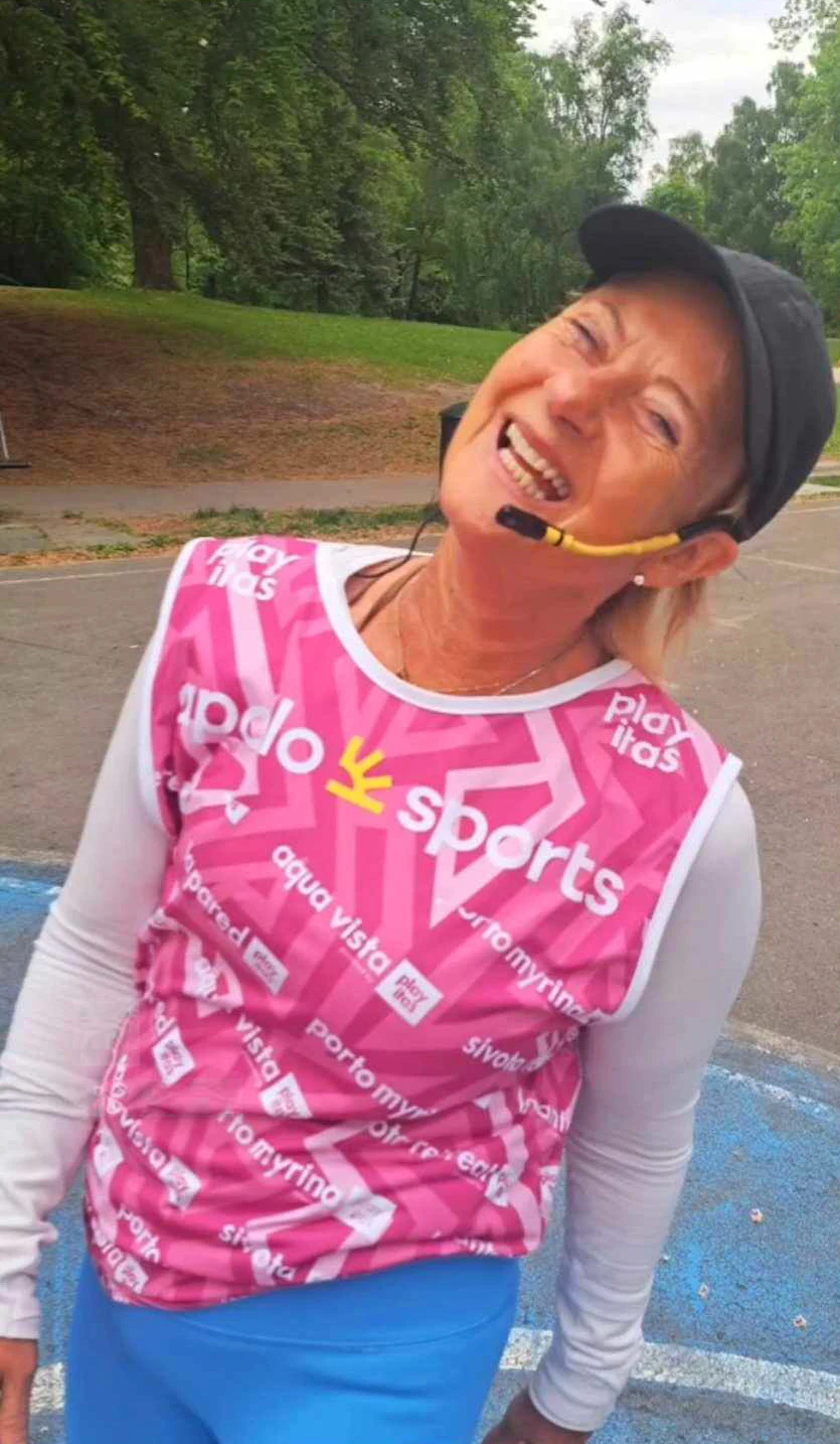 Anne med rosa sporty trøye, caps og mikrofon 