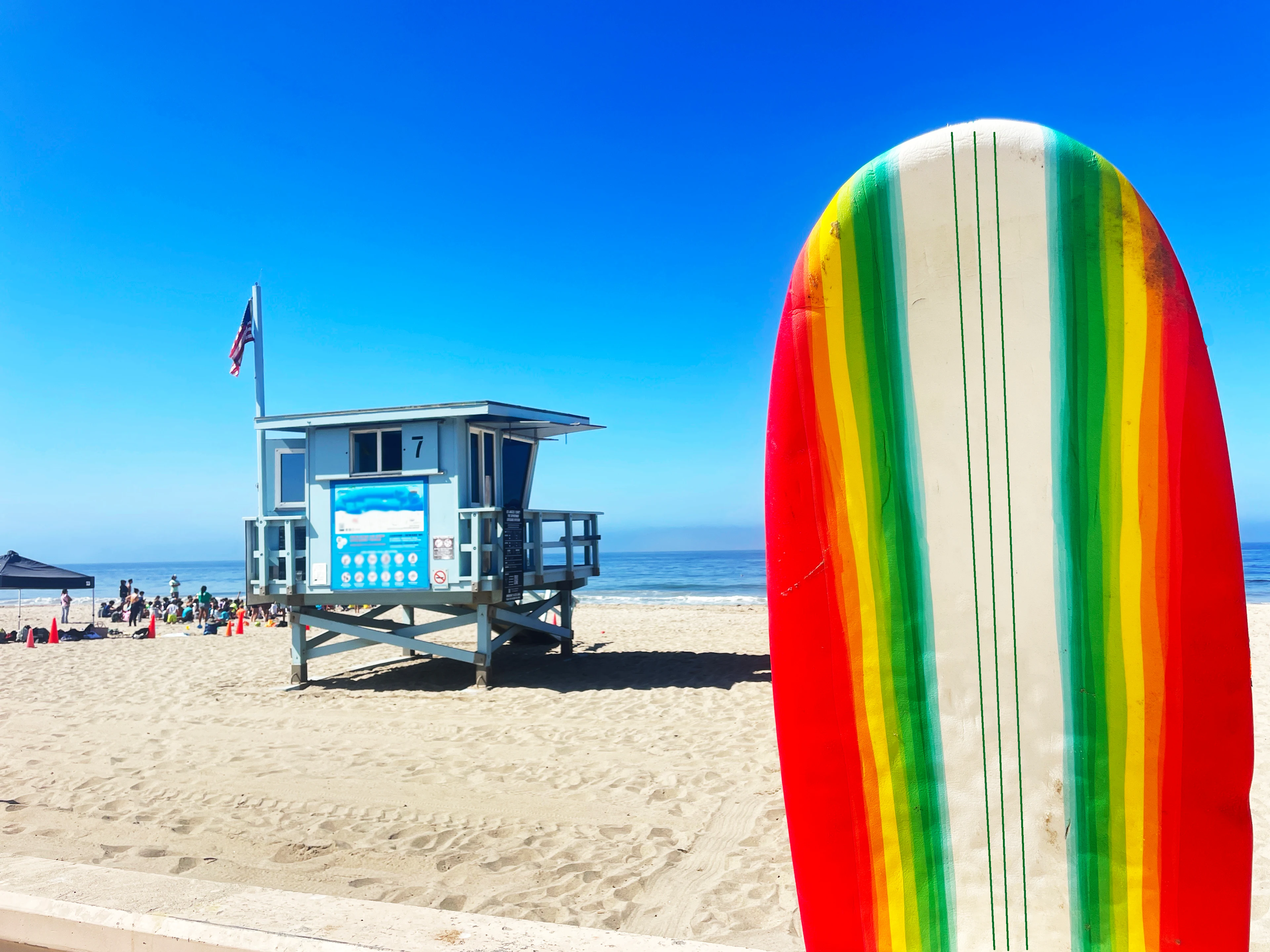 Fargerikt surfebrett og badevakttårn på Zuma Beach i Malibu, Los Angeles.