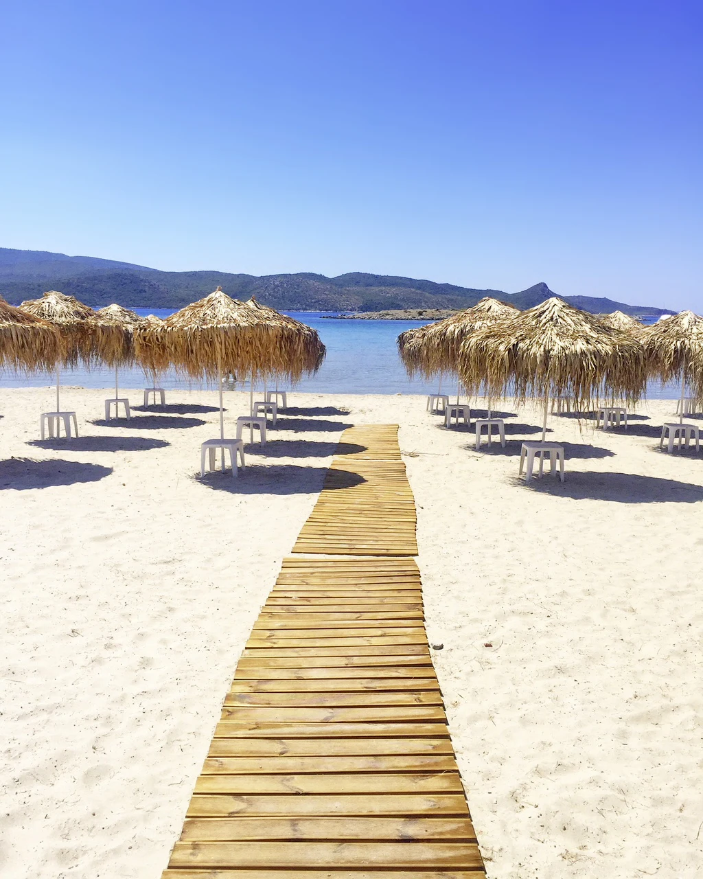 Psili Ammos-strand met stroparasol en blauwe zee op de achtergrond