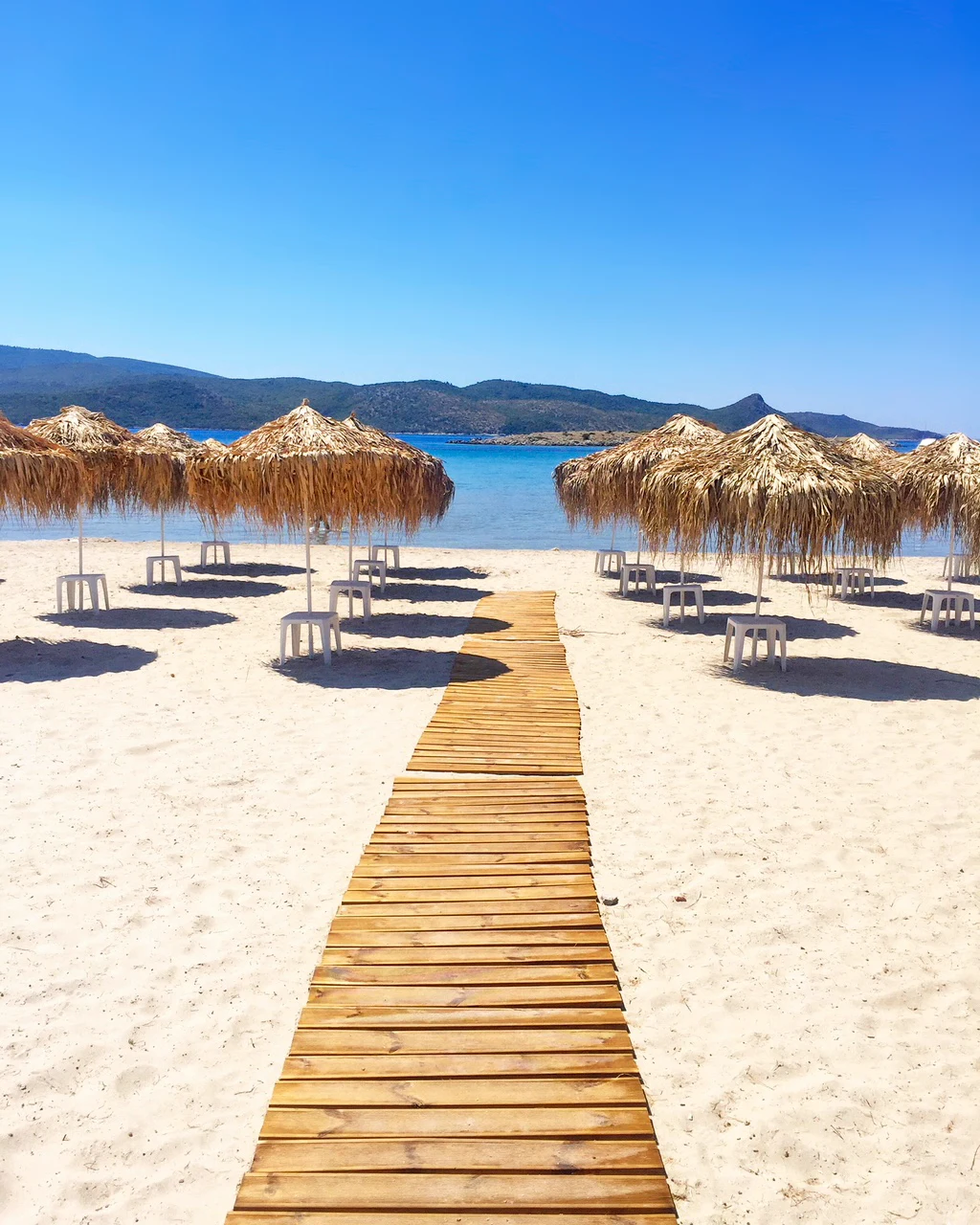 Psili Ammos-strand met stroparasol en blauwe zee op de achtergrond