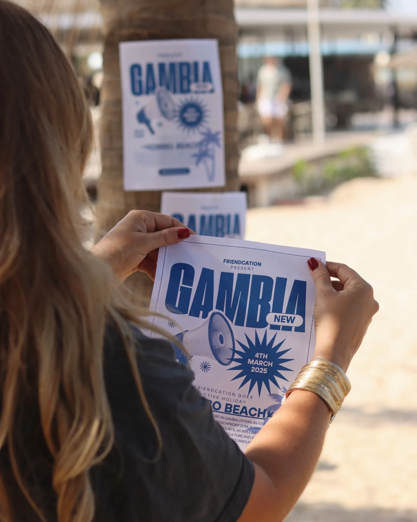 Kvinna som håller i en flyer där det står GAMBIA