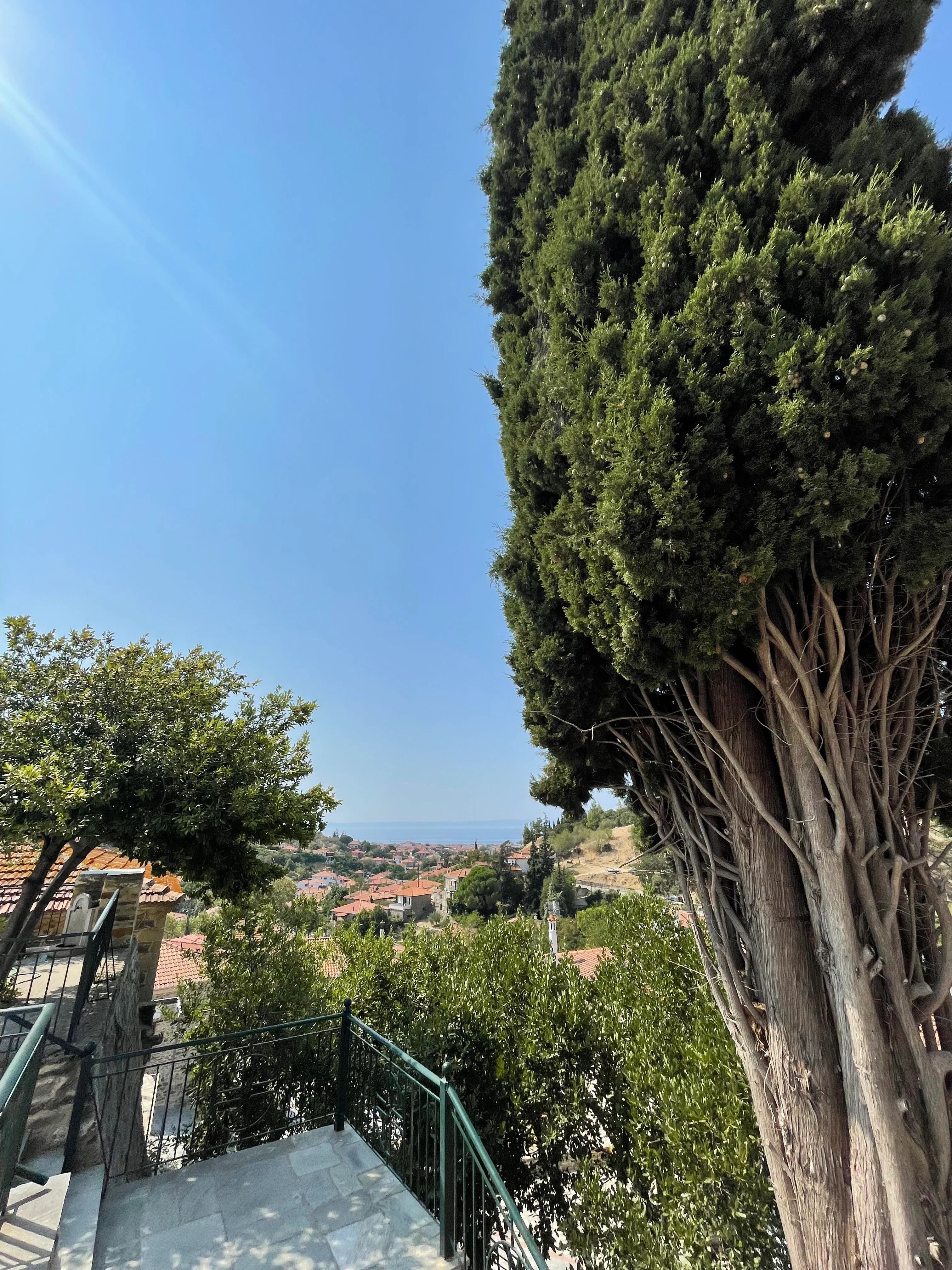 Utsikt från gamla Nikiti på Halkidiki med charmiga hus, lummig grönska och det glittrande havet i bakgrunden.