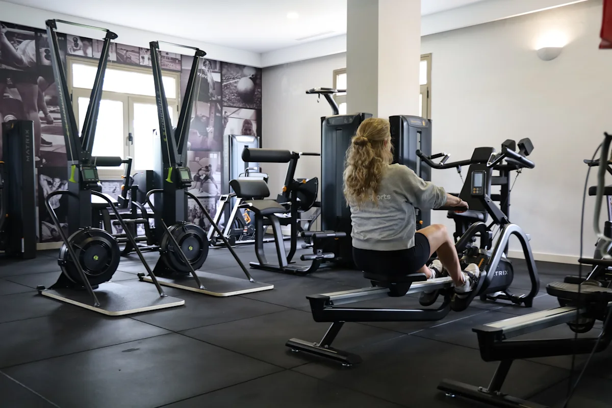 Kvinde på en romaskine i et fitnessrum