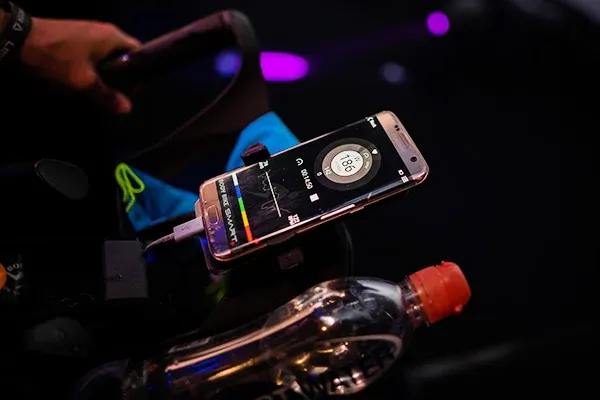 Telefon med en träningsapp öppen på en spinningcykel