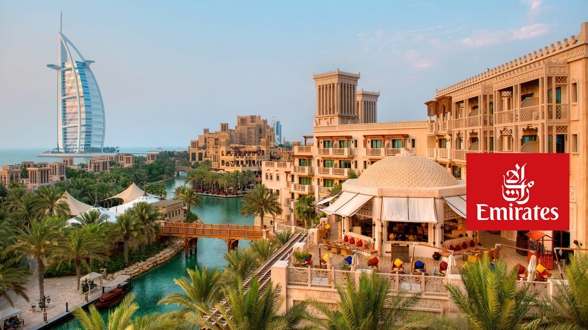 Billedet viser det centrale Dubai med det velkendte hotel Burj Al Arab i baggrunden. Flyselskabets Emirates logo er også synligt på billedet.