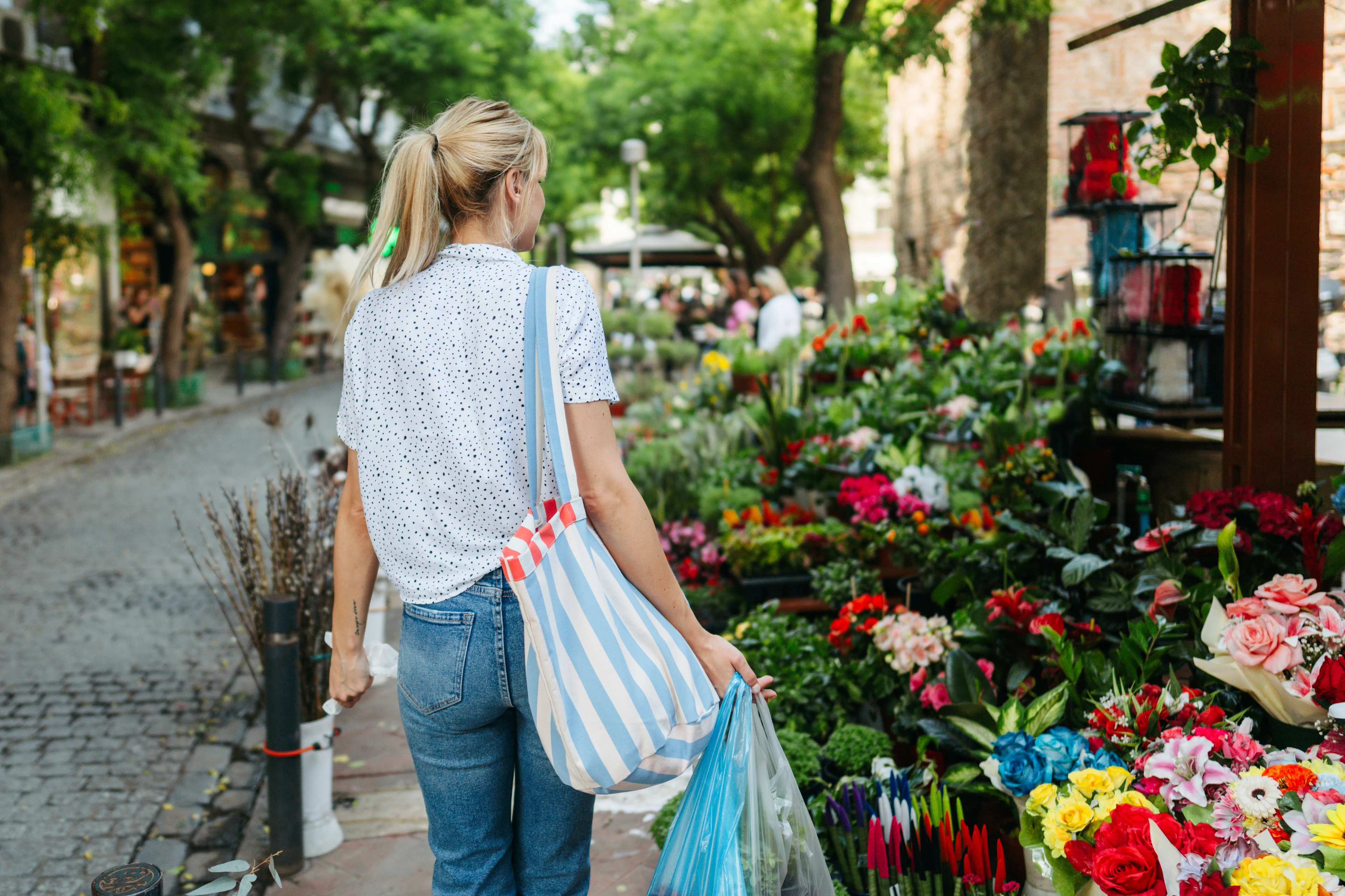 Kvinna som shoppar på en blomstermarknad i Thessaloniki