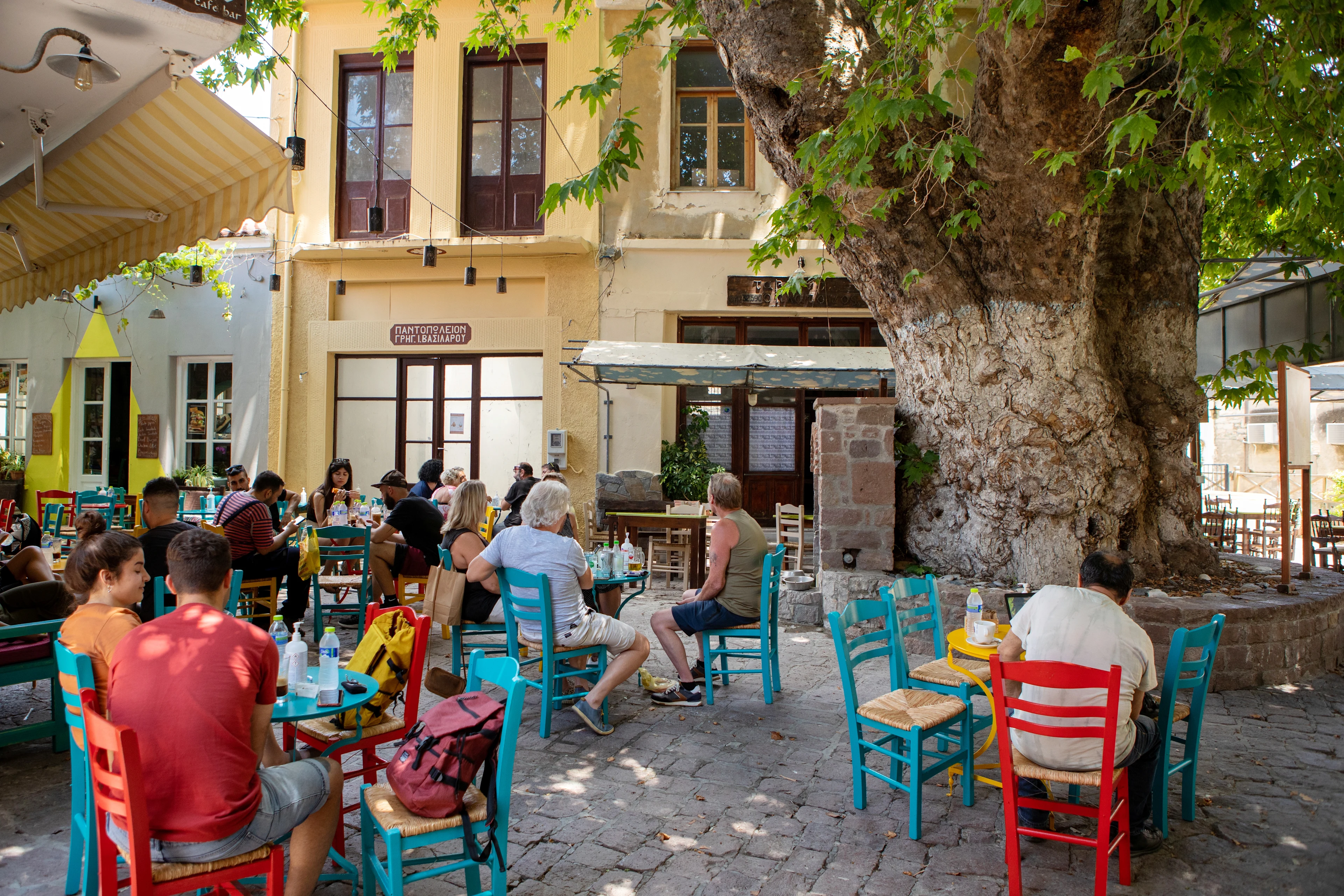 Folk sitter og drikker kaffe på torget i Plomari
