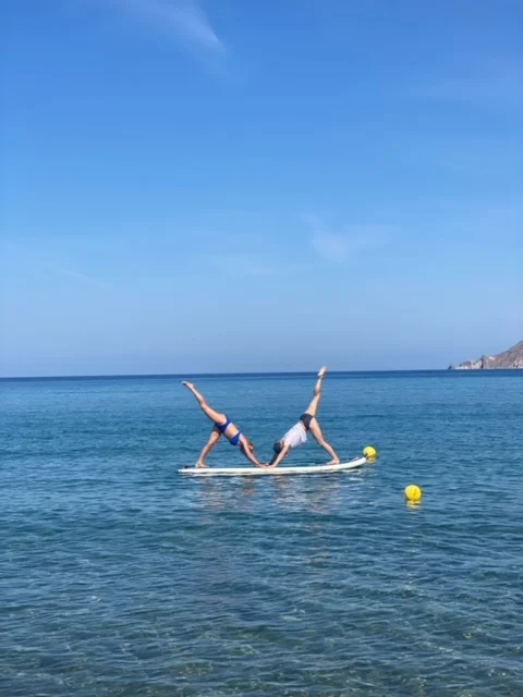 To kvinder laver yoga på sup