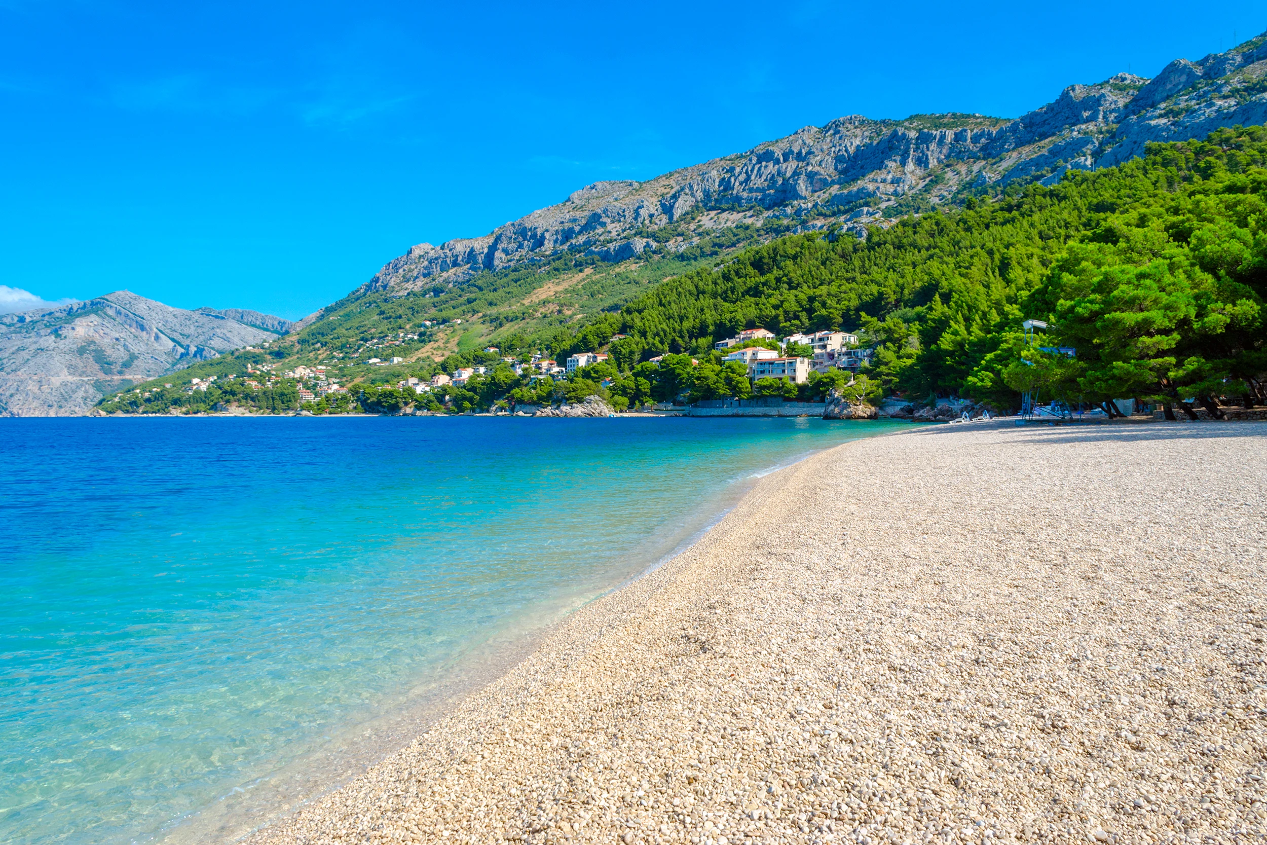 Strand med krystallklart vann i vakre omgivelser i Brela, Kroatia