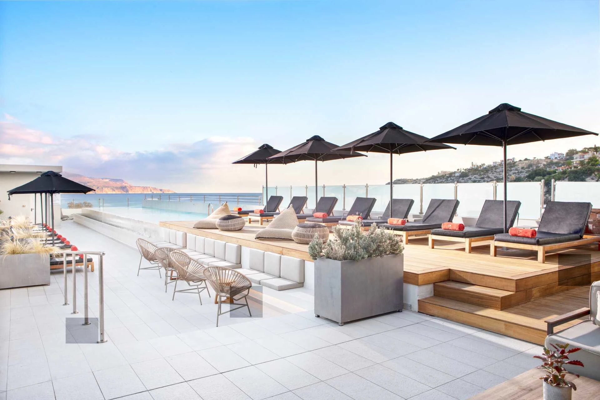 Fra bassengområdet på Almyrida Resort med komfortable solsenger og havet i bakgrunnen.