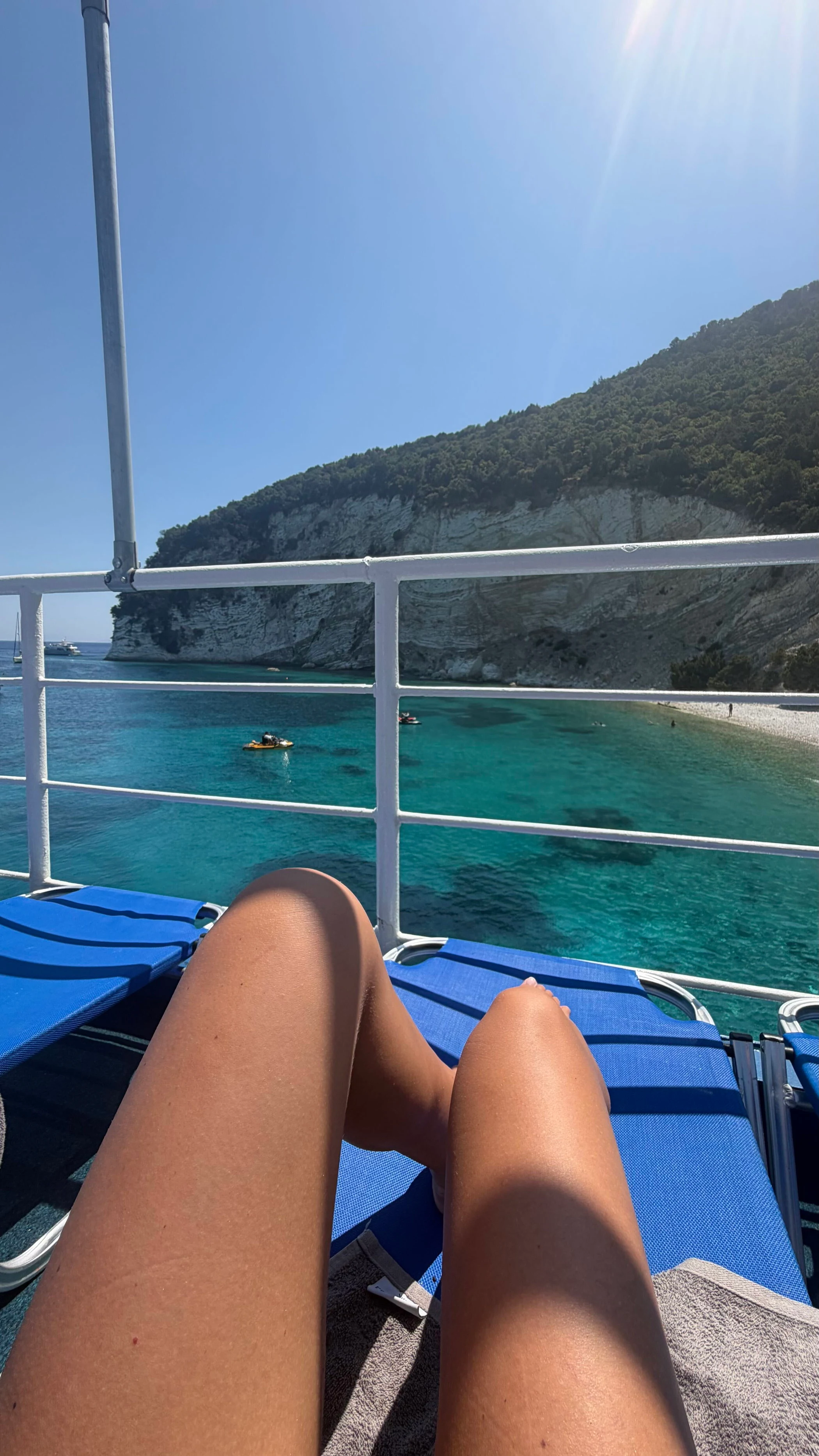 Line kopplar av ombord på en båt med utsikt över turkost vatten på Lefkas.