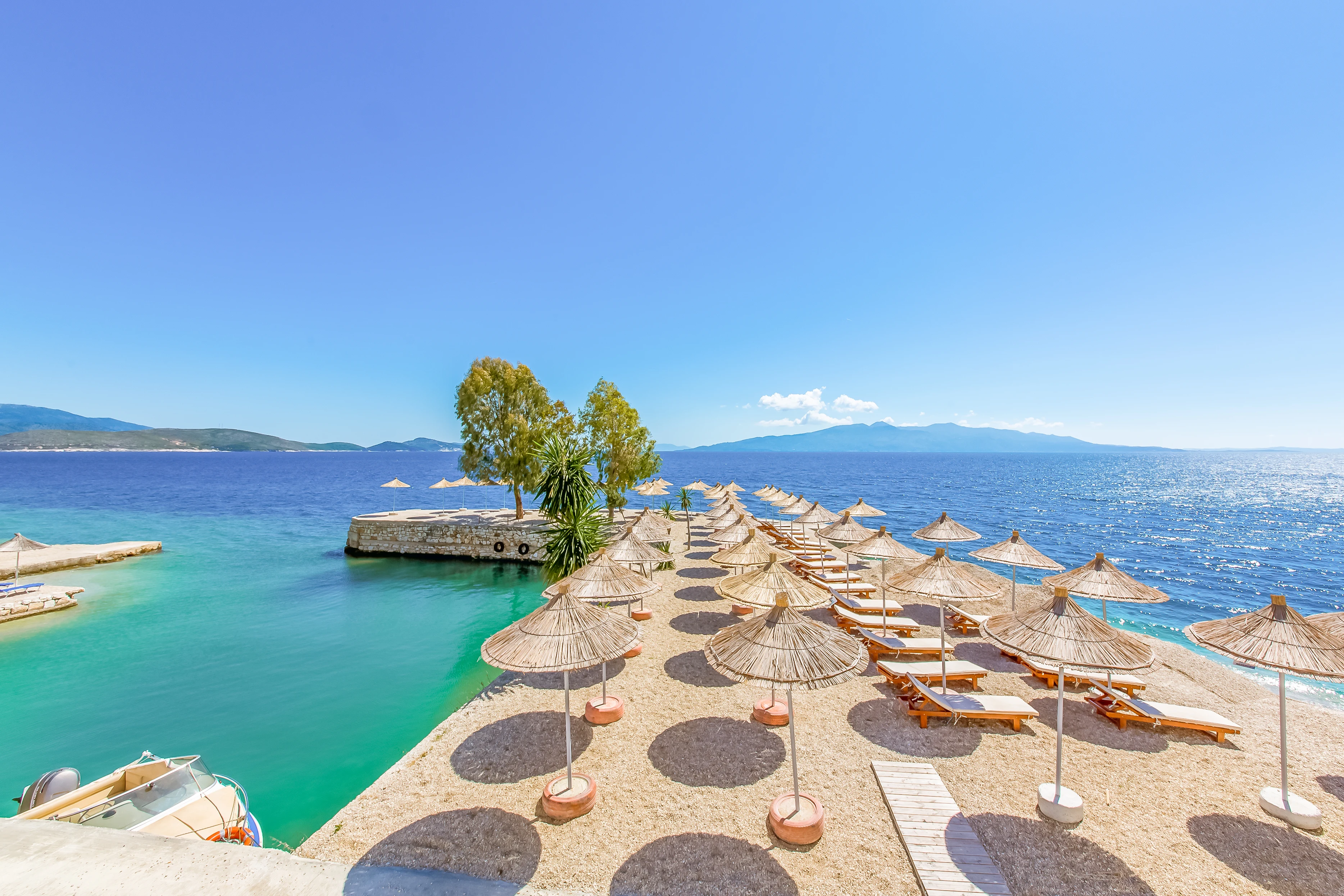 strand i Saranda med solstolar och parasoll