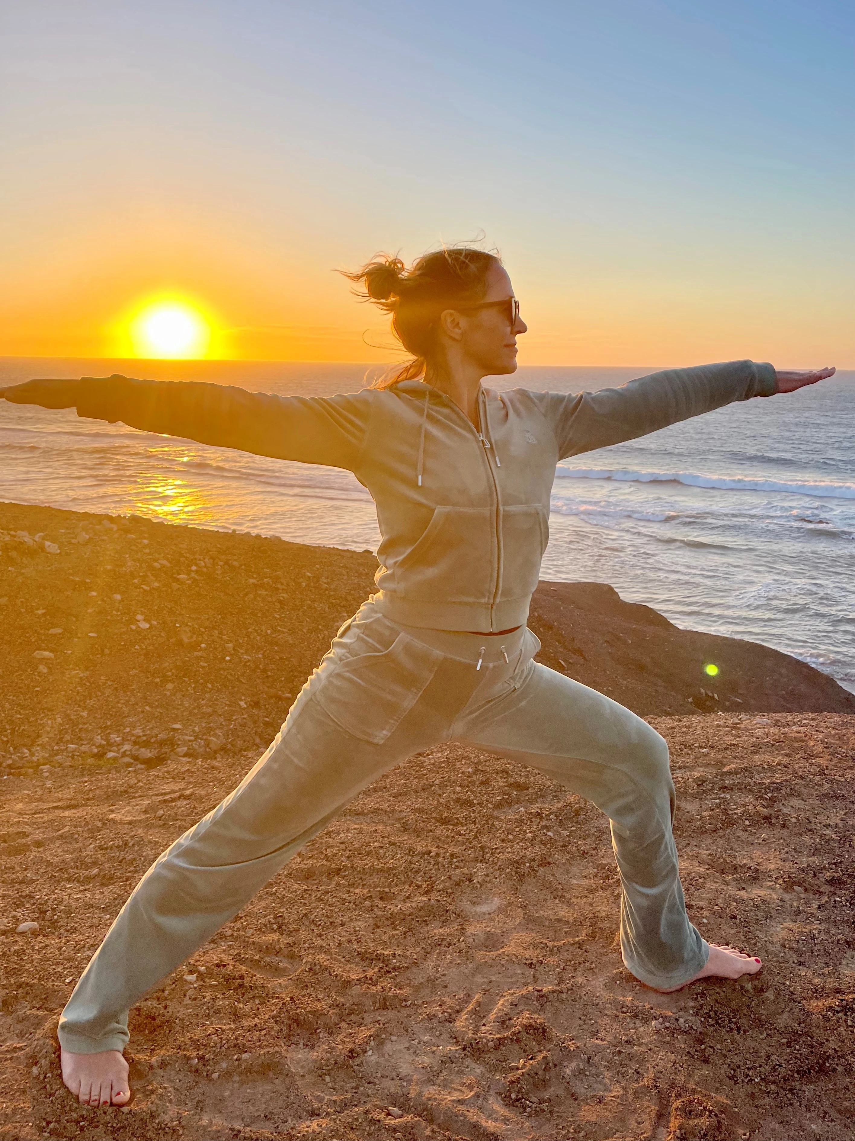 Cecile Eggen i yoga posisjon med solen som står opp i horisonten.