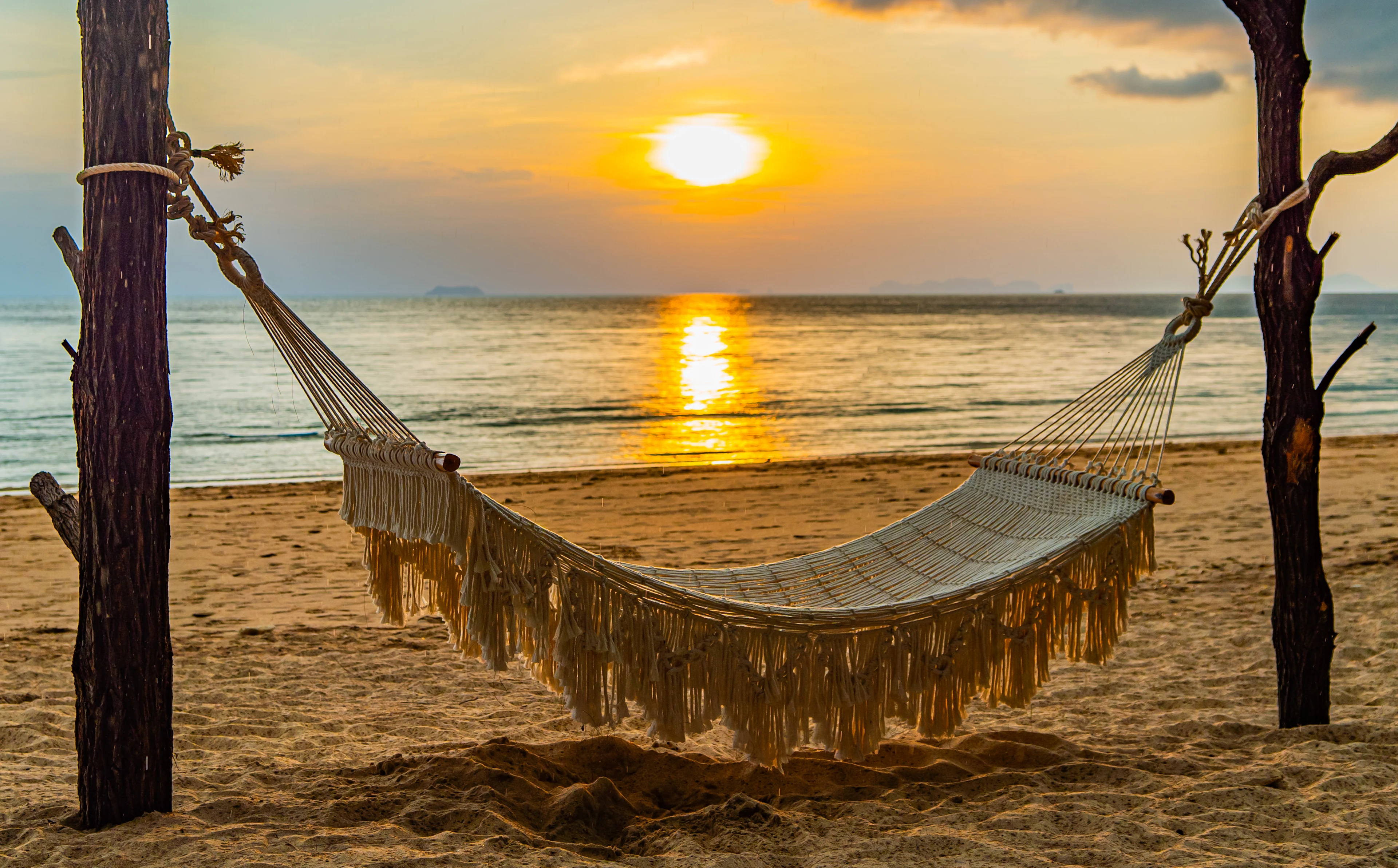 Long Beach på Koh Lanta med en hängmatta vid havet och solnedgång över Andamansjön.