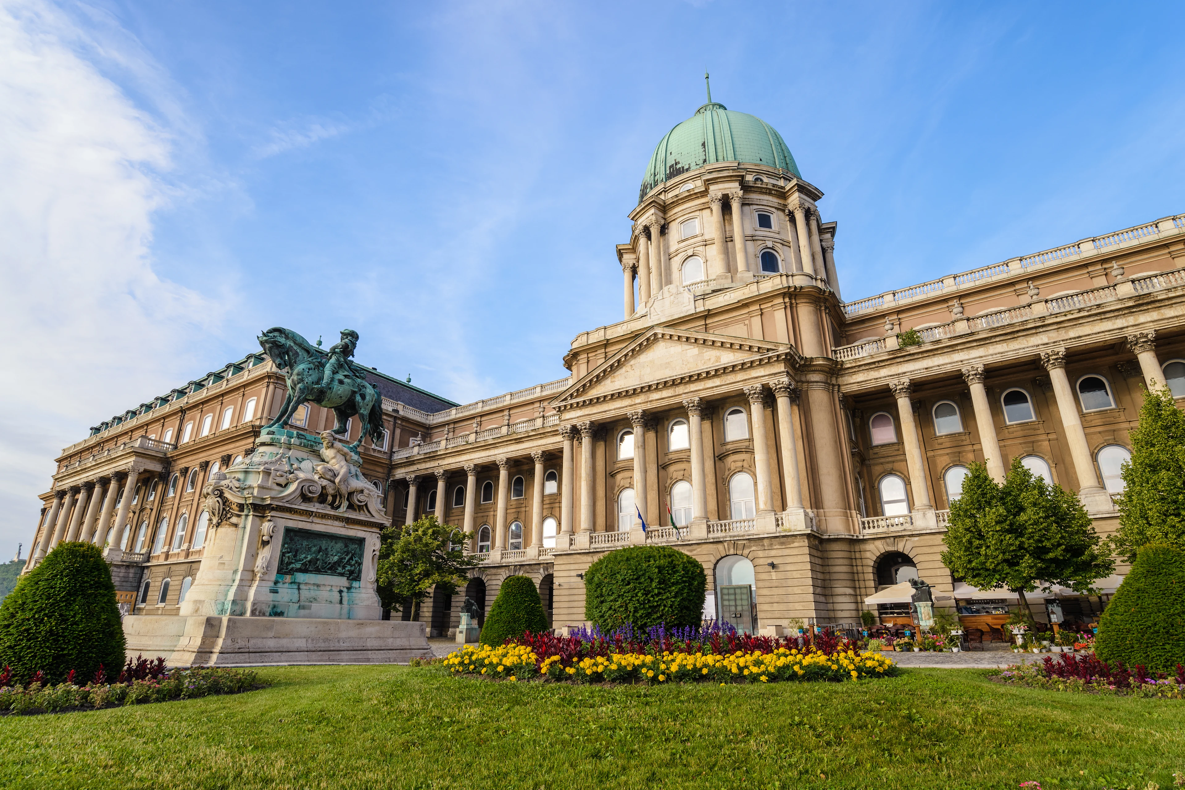 Kungliga slottet på Slottskullen i Budapest med den karakteristiska kupolen och statyn framför byggnaden.