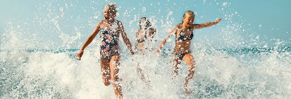 Kinderen springen in de golven