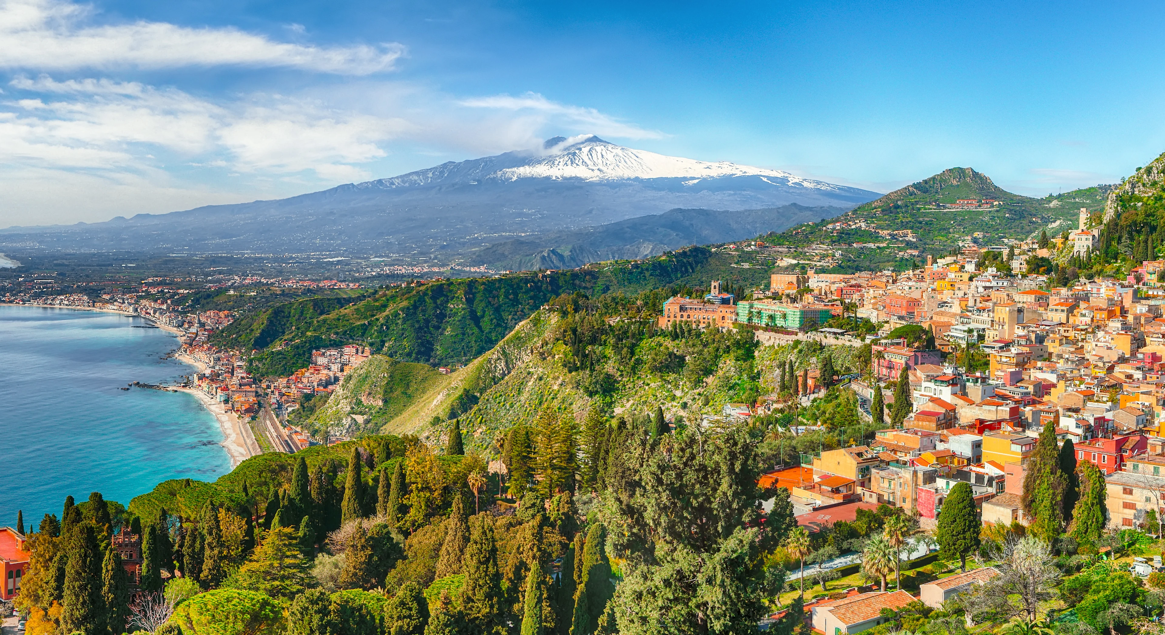 Udsigt over en italiensk by med vulkanen Etna i baggrunden