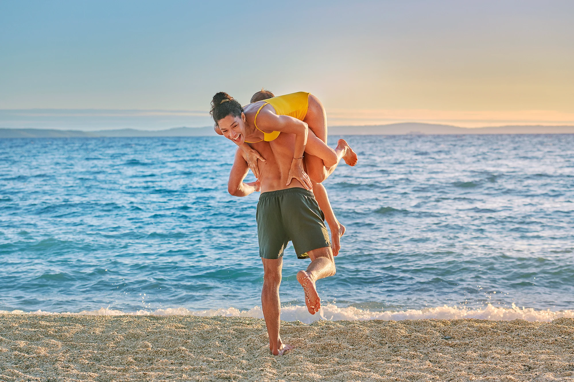 Et par på stranden der han bærer henne.