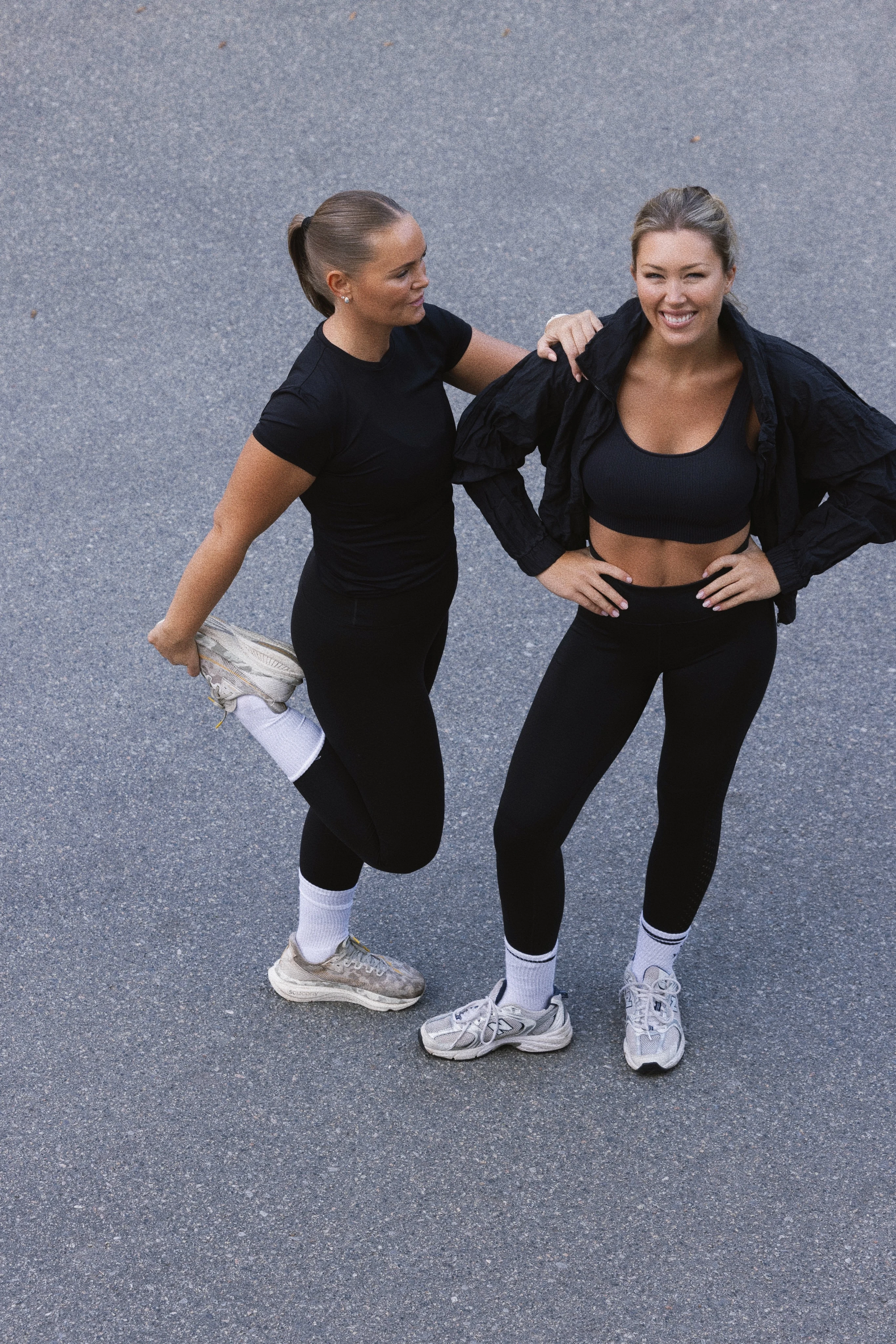 Två personer gör stretchövningar före träning utomhus.