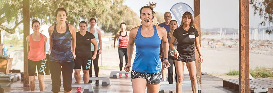 Treningsgruppe som smiler mens de bruker step.