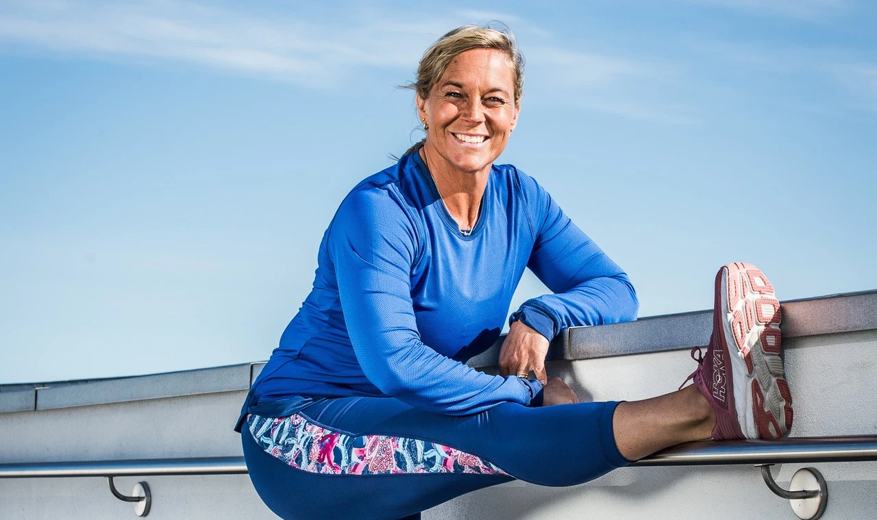 Sofia Åhman stretchar med ett leende på läpparna och blå himmel i bakgrunden