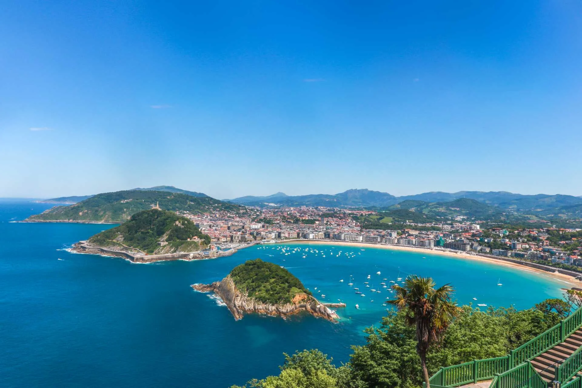 Utsikt över San Sebastián med La Concha-bukten, båtar, ö och strand – populärt resmål i Spanien.