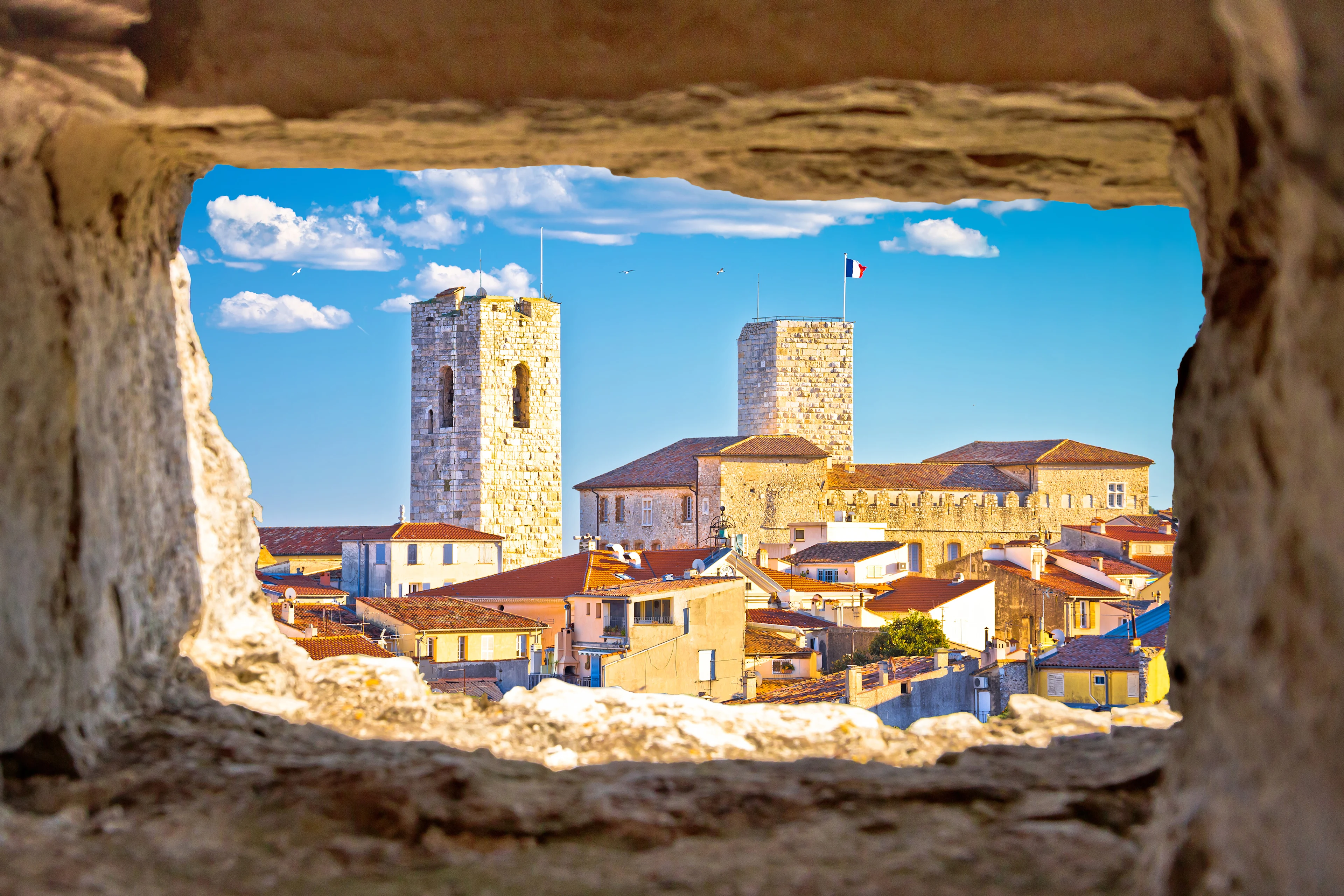 Antibes gamla stad på Franska rivieran med historiska stenbyggnader, stadsmur och de karakteristiska tornen vid Château Grimaldi.