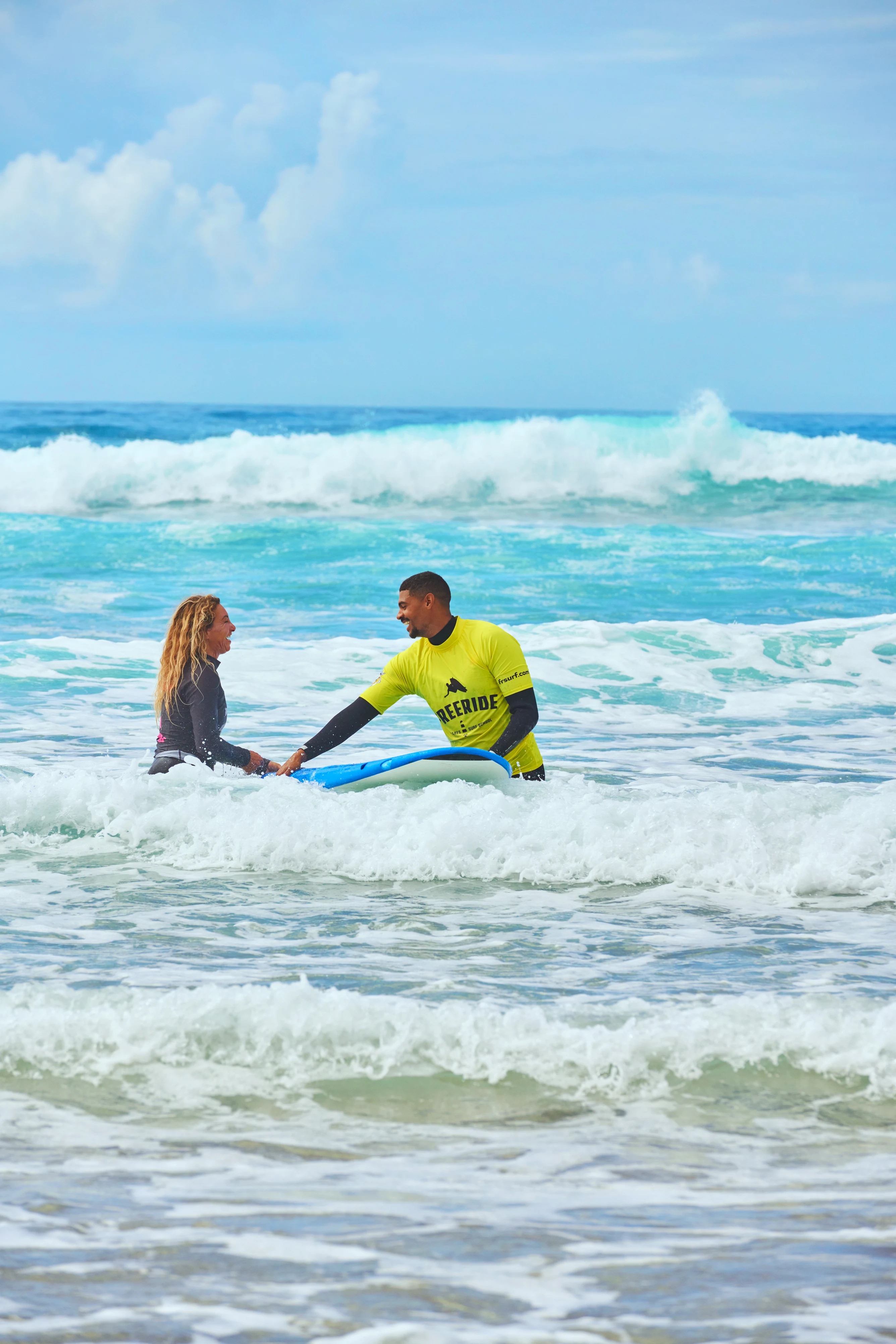 Två personer i havet bland vågor under surflektion