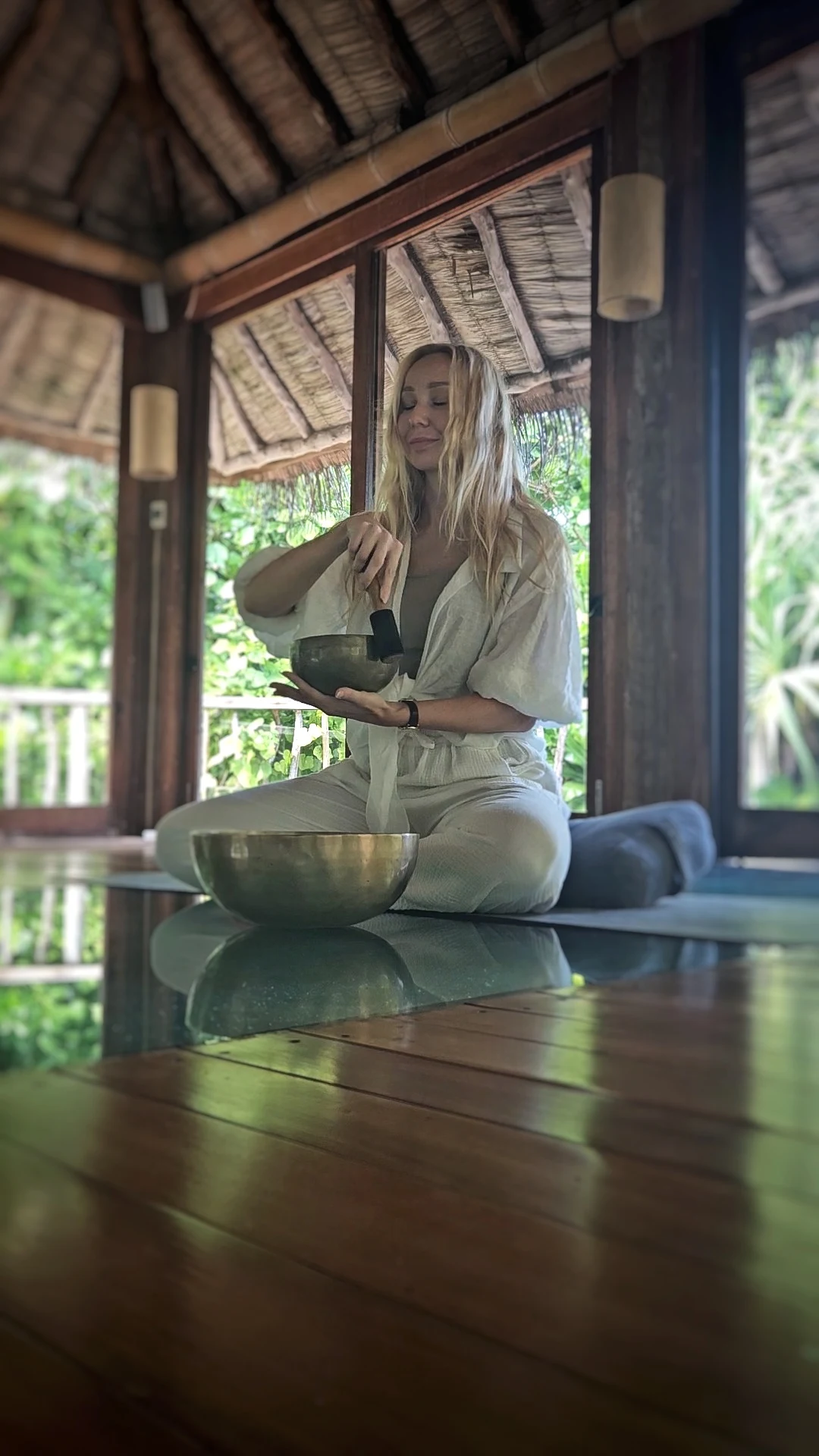 Kvinna sitter i meditationsställning med klangskål