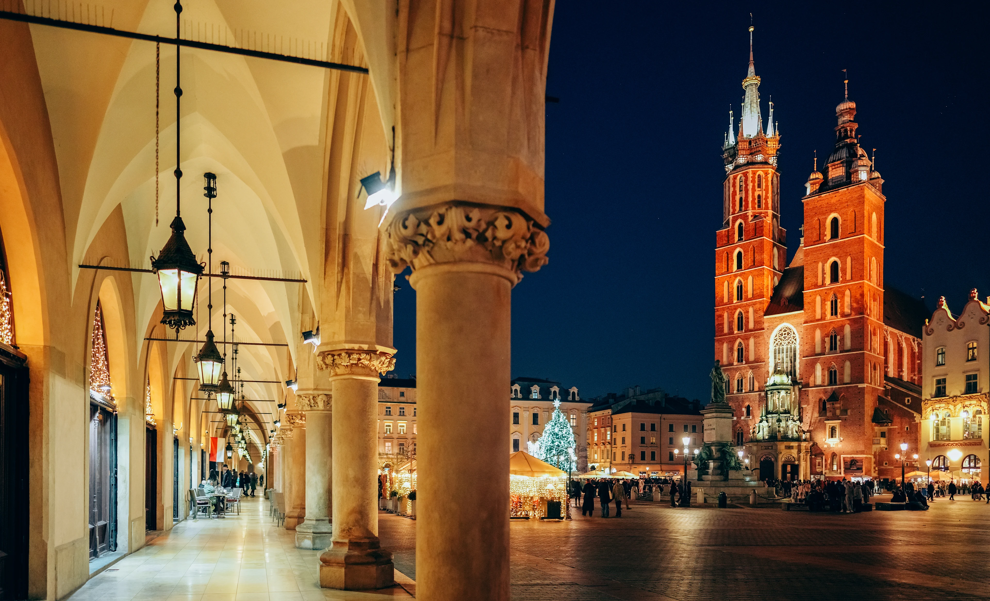 Julmarknaden i Krakow och Mariakyrkan vid Rynek Główny en stämningsfull vinterkväll.