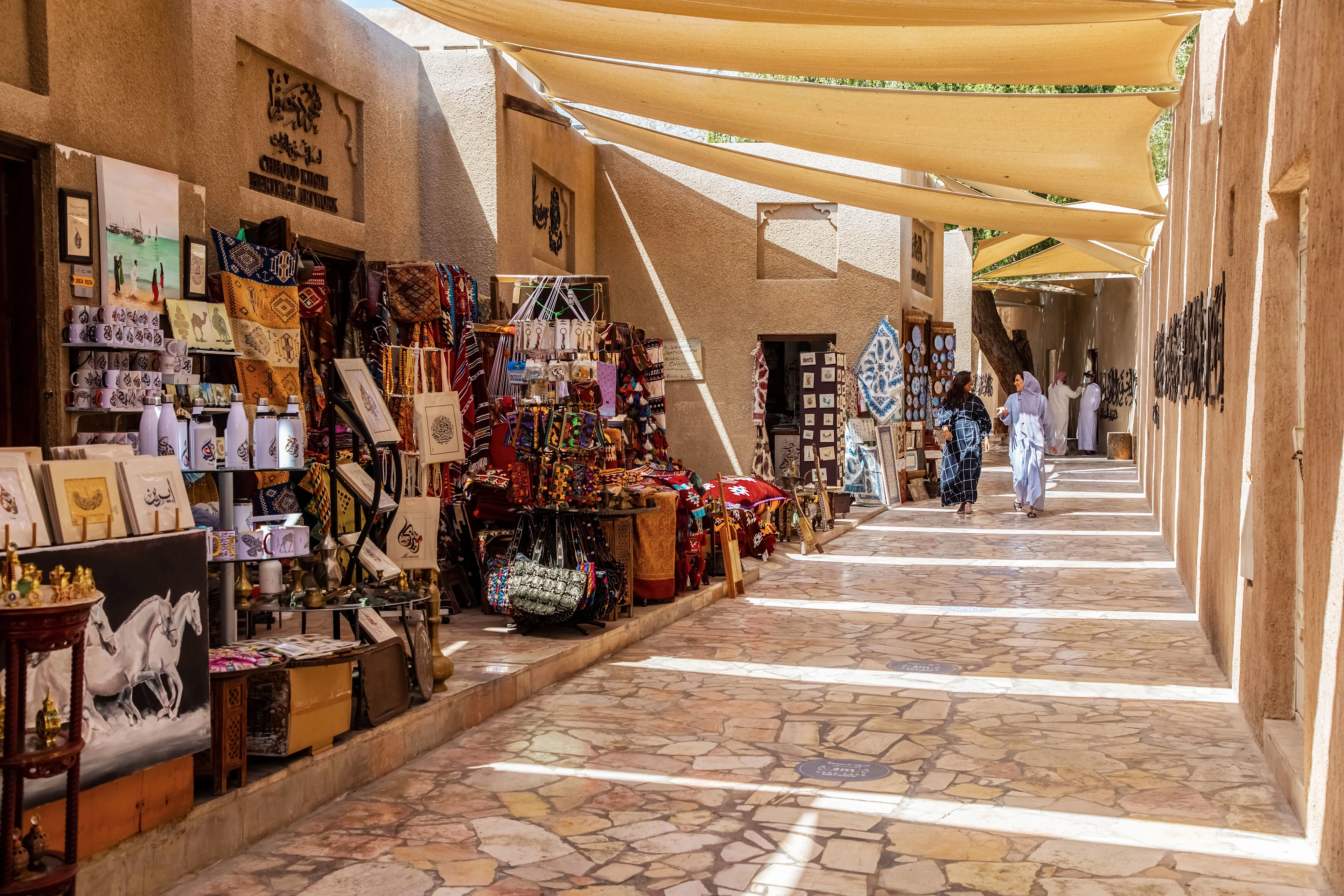 Perinteinen souk Al Fahidissa Dubaissa, täynnä värikkäitä tekstiilejä, matkamuistoja ja varjoa tarjoavia kangaskatoksia