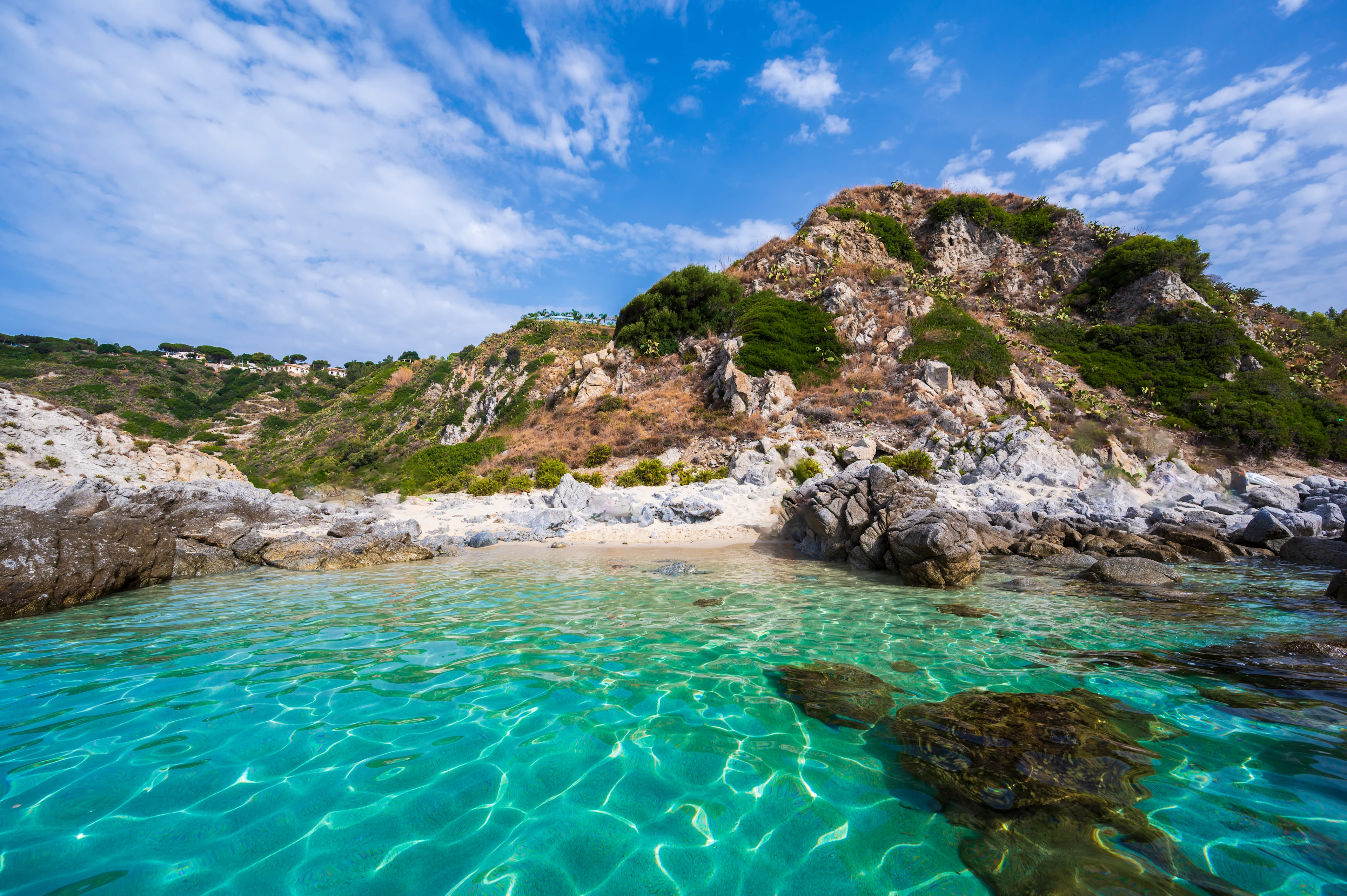 Vackert och kristallklart vatten vid Groticelle beach, Capo Vaticano