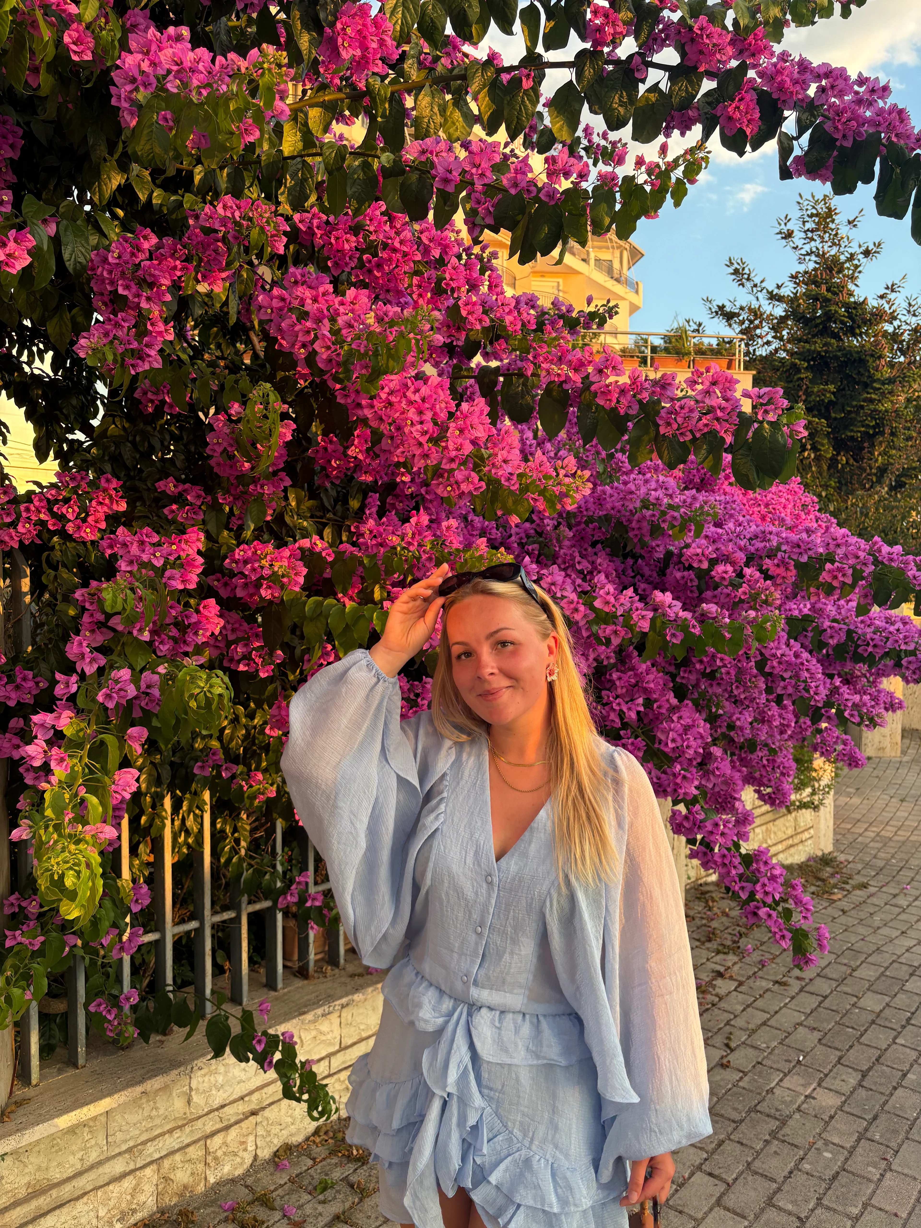 Person med rosa blommor i bakgrunden. 