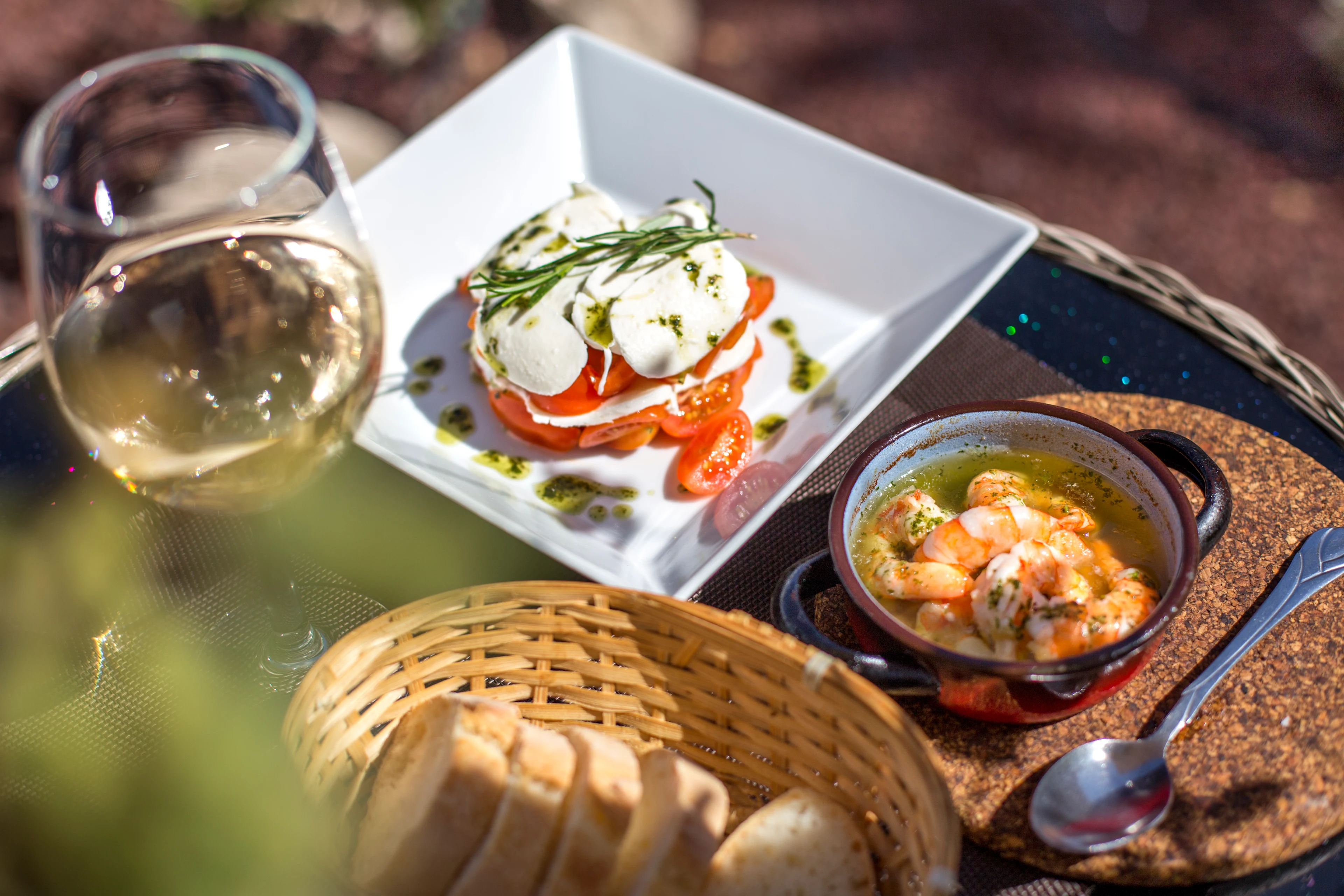 Kanariska delikatesser med färska råvaror och ett glas vitt vin på en solig uteservering på Teneriffa.