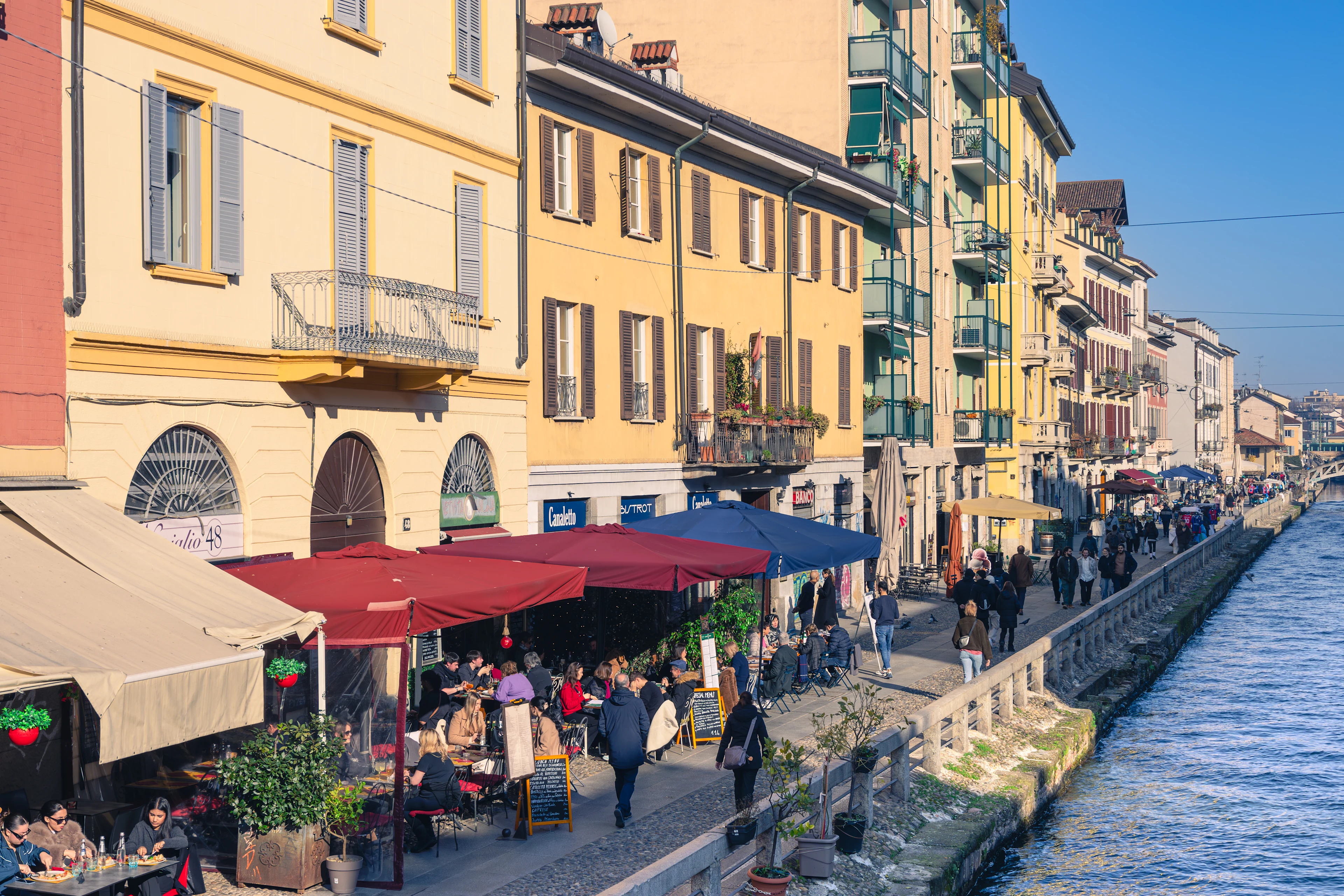 Udsigt over charmerende huse og udendørscaféer langs Naviglio Grande i Milano