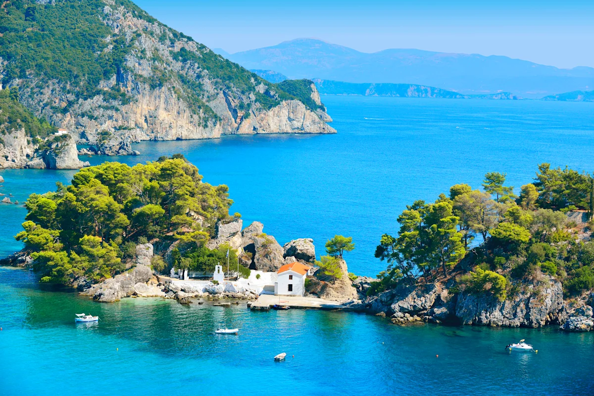 Lille ø i havet med en bygning og både rundt 