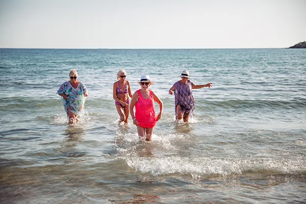 4 eldre som hygger seg i strandkanten