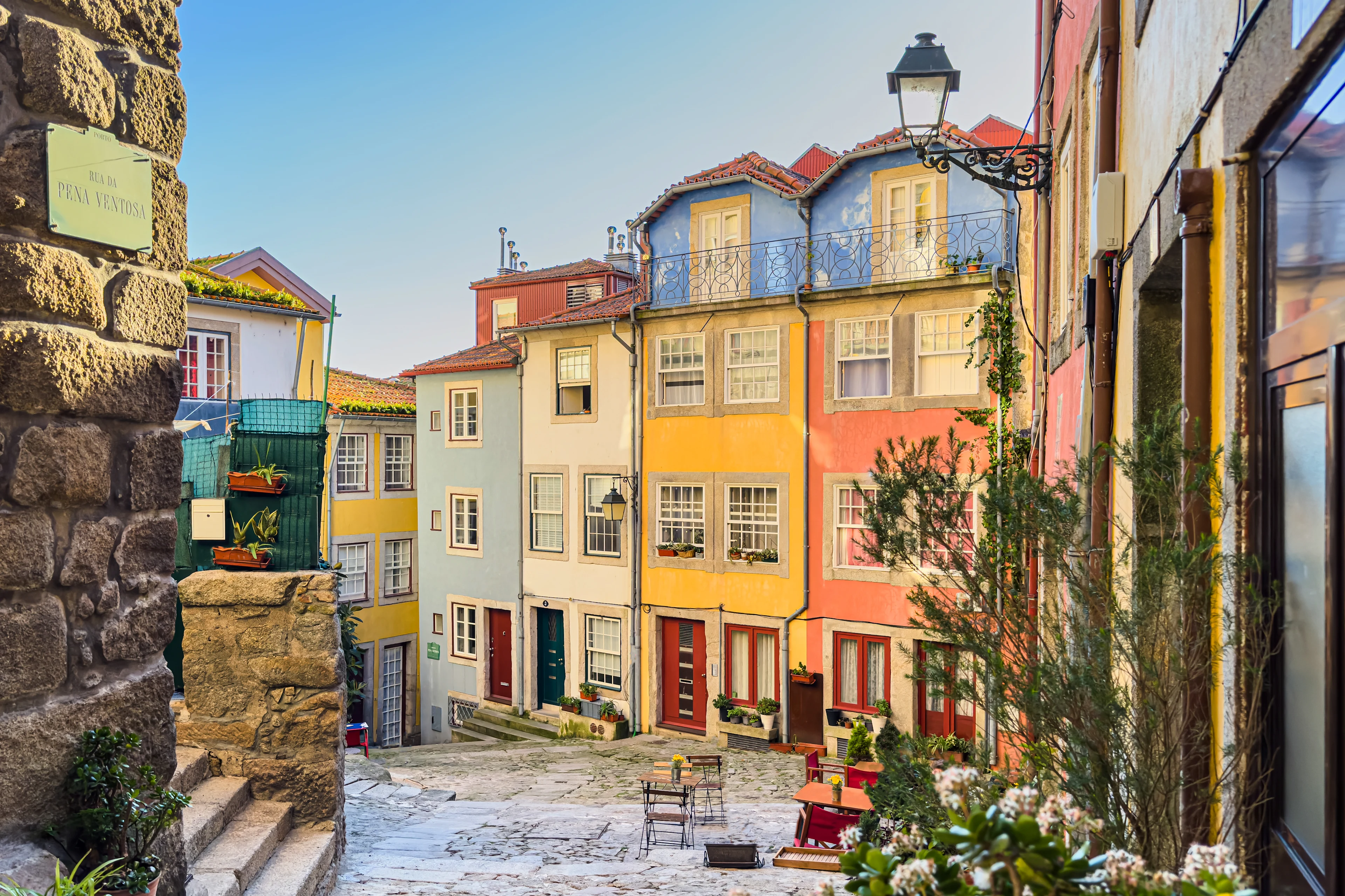 Färgglada hus längs en kullerstensgata i Porto, Portugal, med charmiga fasader och små torg i stadens historiska kvarter.