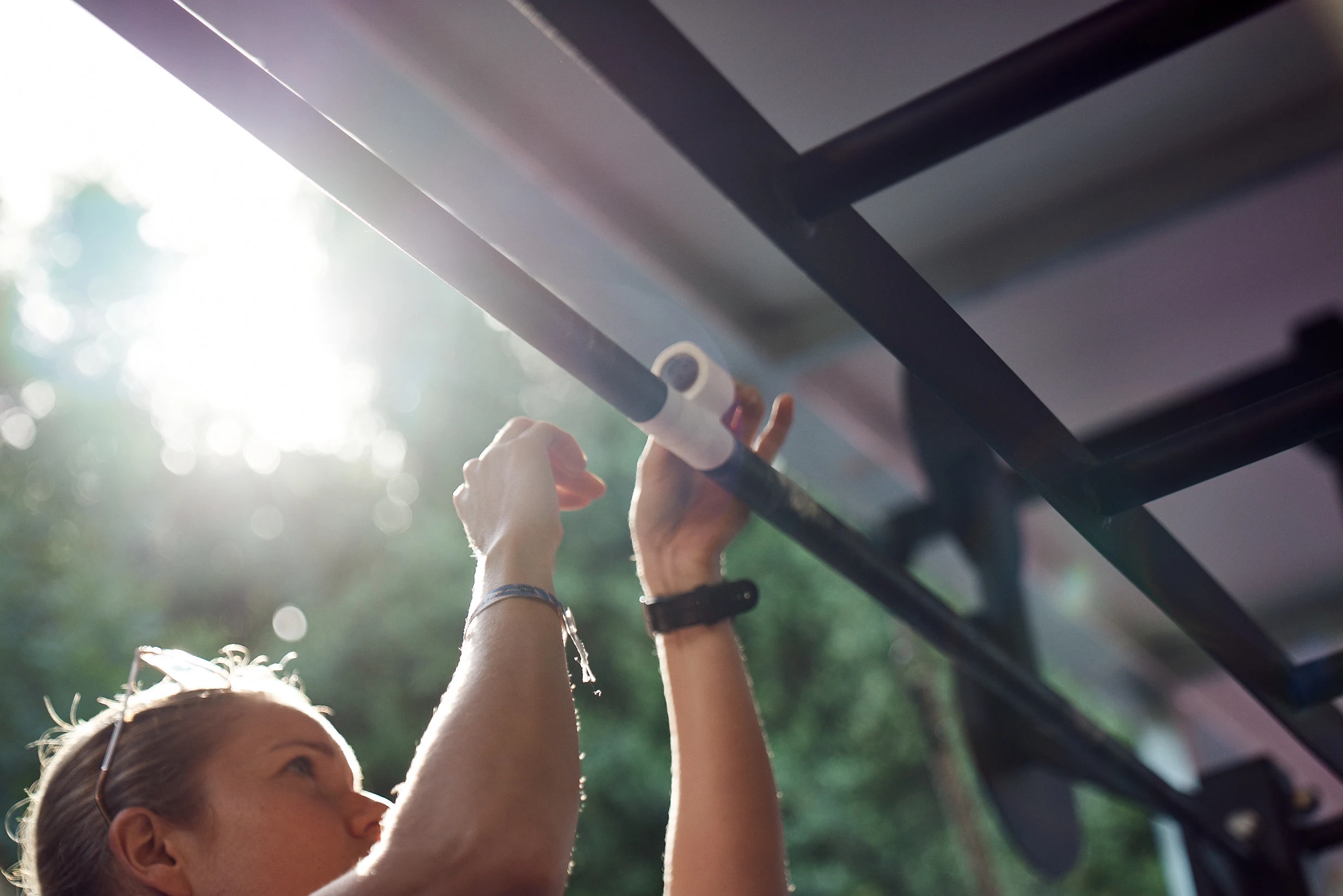 A girl taping the rig in the WOD box for extra grip