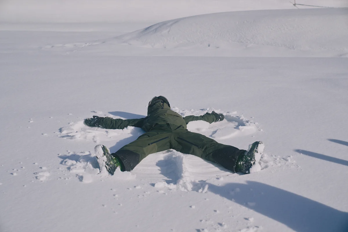 Person som lager snøengel i urørt snø på en åpen, snødekt overflate