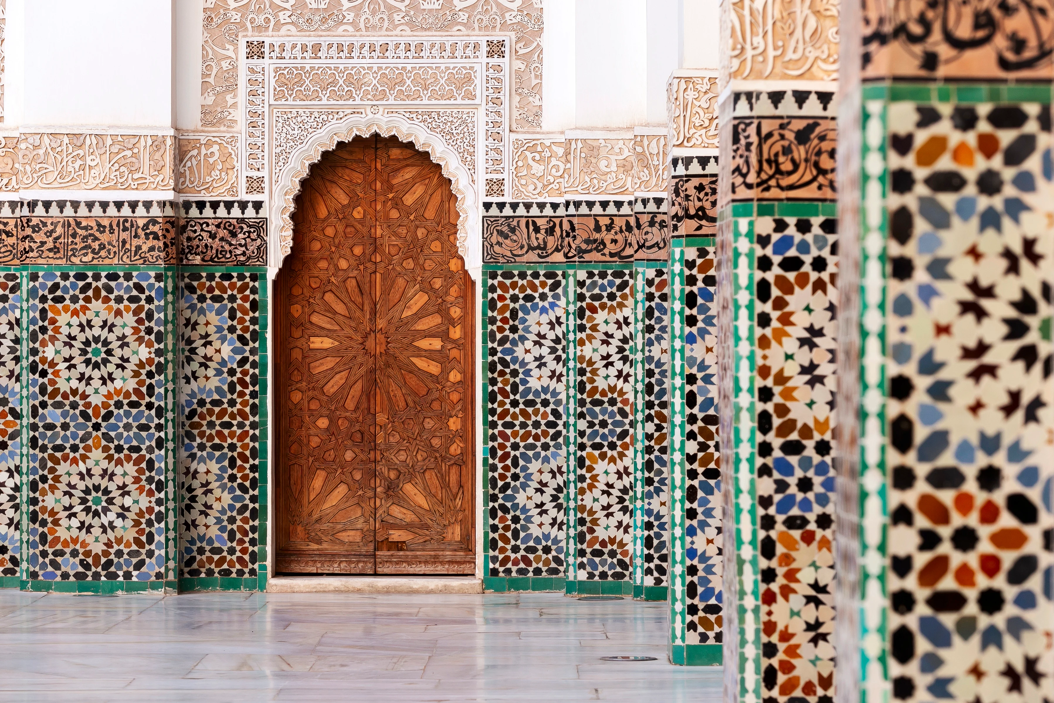 Vacker dörr i Marrakech samt mosaikklädda pelare